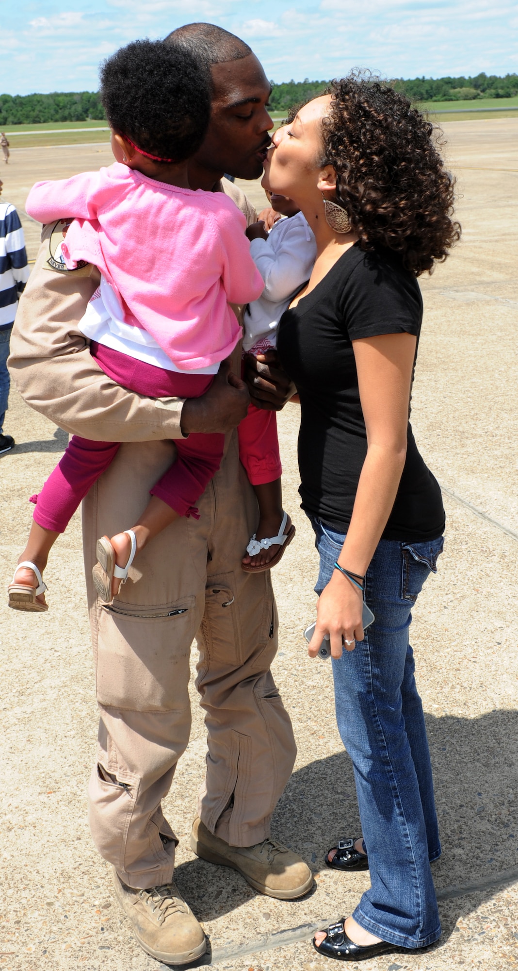 Tech. Sgt. Julius Brown, a 61st Airlift Squadron loadmaster, kisses his wife on the base flight line May 15, 2011, at Little Rock Air Force Base, Ark. Sergeant Brown was one of 50 61st AS Airmen who returned from operations at Joint Base Balad, Iraq. (U.S. Air Force photo/Airman 1st Class Rusty Frank)