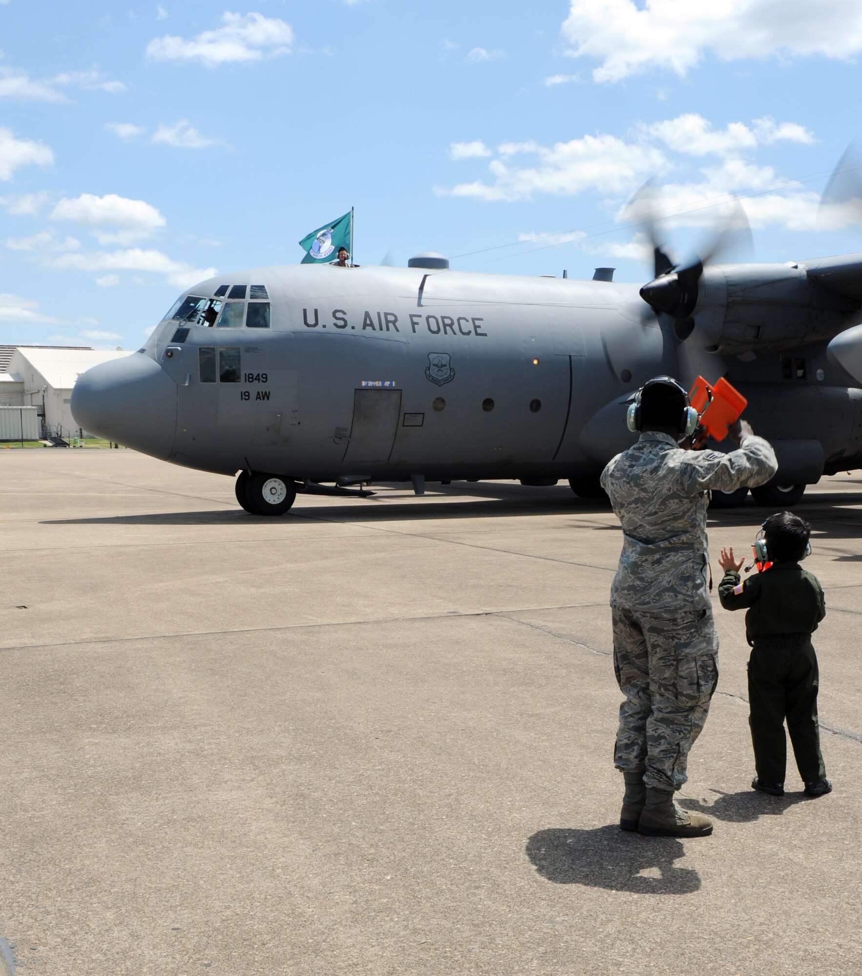 Ian King, son of Lt. Col. Dennis King, 61st Airlift Squadron commander, waves to his father as his C-130 taxis in on the base flight line May 15, 2011, at Little Rock Air Force Base, Ark. Colonel King was assigned to the 777th Expeditionary Airlift Squadron or "Triple 7 Dueling Dragons," the most forward deployed C-130 airlift unit engaged in the Iraqi theater of operations. (U.S. Air Force photo/Airman 1st Class Rusty Frank)