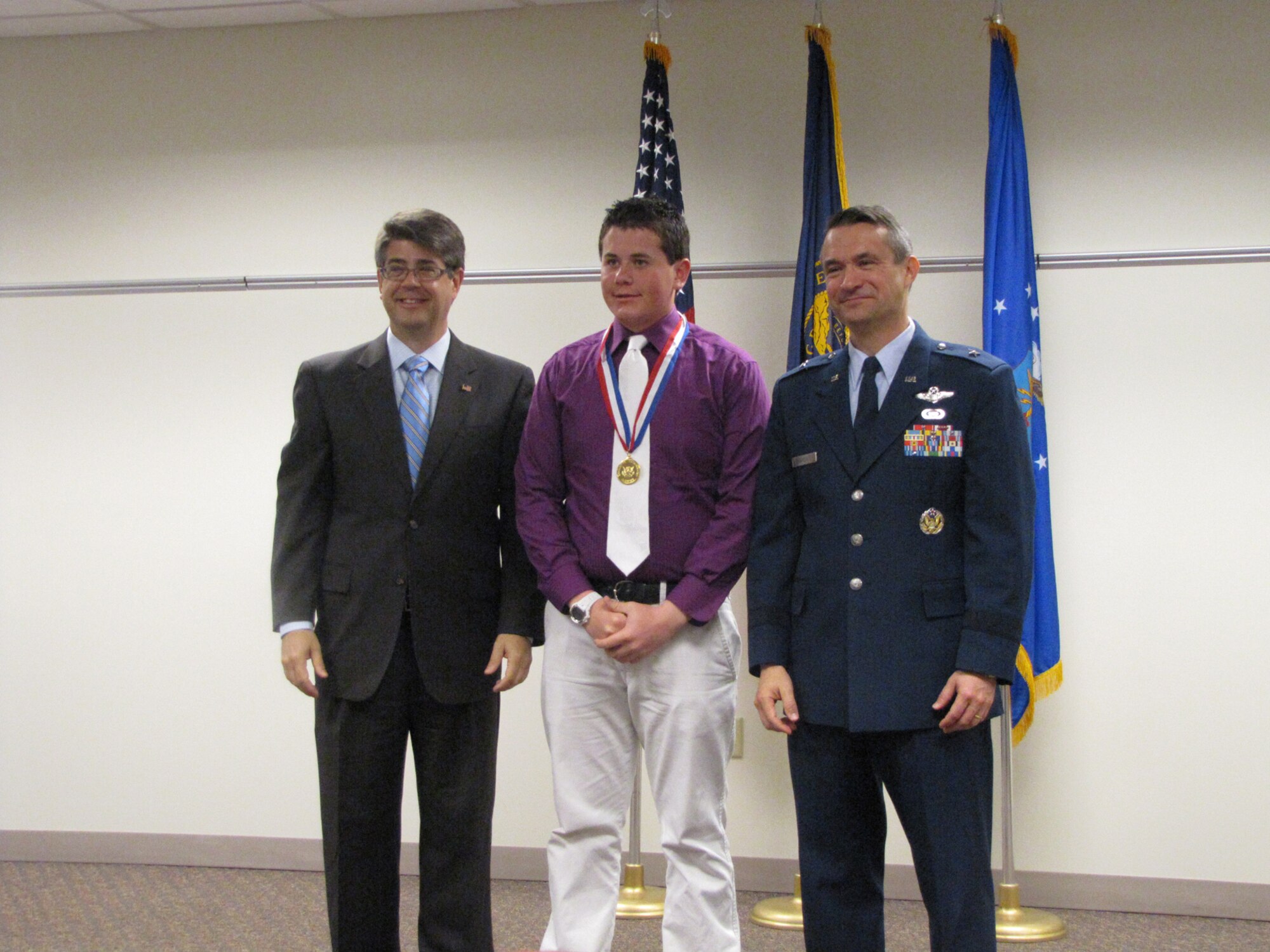 OFFUTT AFB, Neb. – Representative Lee Terry and 55th Wing commander Brig. Gen. Donald J. Bacon presents a congressional gold medal to Philip Wier during a ceremony May 17 at the Bellevue Public Schools Welcome Center in Bellevue. Contestants are awarded based on points earned in four areas: volunteer public service, personal development, physical fitness and expedition/exploration activities.