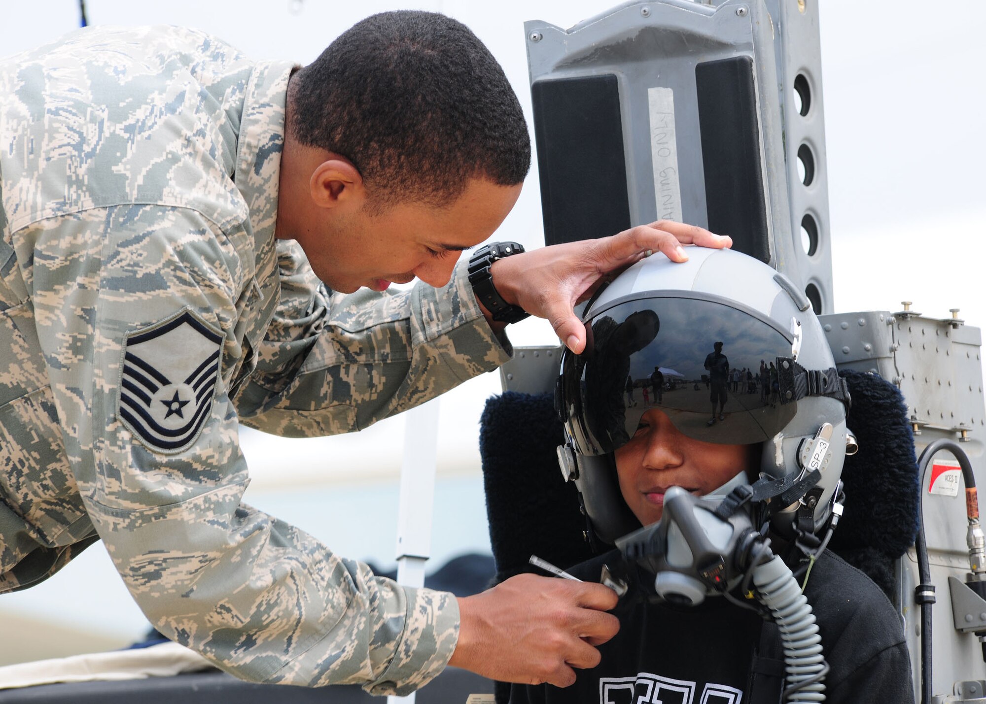 Master Sgt. Jason Scott, 121th Fighter Squadron, assists Wally Macon IV in trying on aircrew flight equipment during the 2011 Joint Service Open House here May 20. JSOH affords the public an opportunity to meet the men and women of the Armed Forces and see military equipment from the Navy, Marines, Army, Air Force, and Coast Guard. JSOH is planned and conducted through the efforts of active duty, guard and reserve servicemembers, as well as civilian employees, retirees and family members. (U.S. Air Force photo/Staff Sgt. Nichelle Anderson)