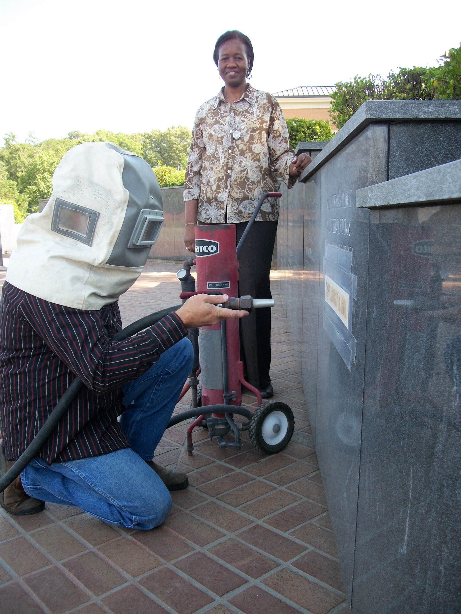 Columbus AFB Historian Dr. Doris Crusoe guides Jimmy Hall of Columbus Marble Works as he prepares to add a name to the Wing Memorial Wall at Smith Plaza May 18.  All wing members are invited to attend the Wing’s Memorial Day Ceremony at Smith Plaza on Thursday, May 26, at 4 p.m. when Captain Jeff Hill’s, class 04-11, name will be officially added to the wall.” (US Air Force Photo by Sonic Johnson)