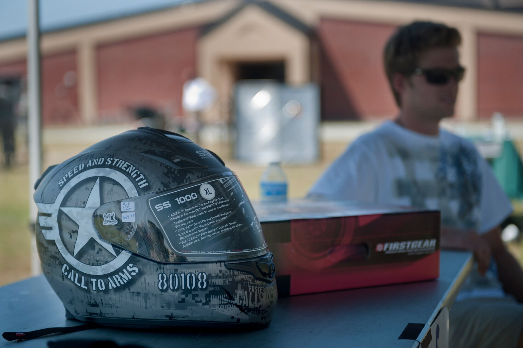 Hunter Aldrich, local mechanic, sits next to a table of safety equipment at the Critical Days of Summer kick-off event at Moody Air Force Base, Ga., May 20. Mr. Aldrich discussed the importance of wearing protective gear when riding motorcycles. (U.S Air Force photo/Airman 1st Class Douglas Ellis)(RELEASED)
