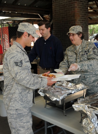 Chief Master Sgt. Georgia Fallaw serves Staff Sgt. during the Chief's Fish Fry held at the Joint Base Charleston - Air Base picnic grounds  May 20.The fish fry is held annually to promote a sense of camaraderie between the reserve and active-duty units on base. Chief Fallaw is the 315th Aircraft Maintenance Squadron Gold Flight Chief. Sergeant Breaux is the 628th Communications Squadron Project Manager. (U.S. Air Force photo/Airman 1st Class Ian Hoachlander) 