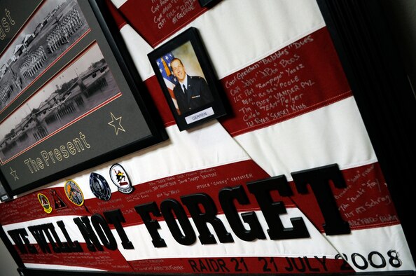 Maj. Mark Brown, who was assigned to the 96th Bomb Squadron in 2008, draped a flag memorial for the fallen aircrew of RAIDR 21 to honor and remember them. RAIDR 21 was the call sign of a B-52H from Barksdale Air Force Base, La., which tragically crashed off the coast of Guam July 21, 2008, killing the six aircrew. (U.S. Air Force photo/Staff Sgt. John Gordinier)(RELEASED)