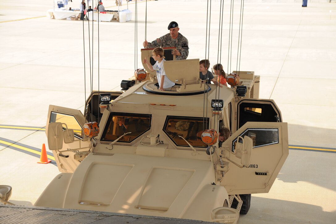 Children explore the inside of an Army MRAP under a Soldier’s watchful eye, Friday at the 2011 Joint Service Open House.  The MRAP is tethered to a Russian AN-124-100 in preparation for their lift capability demonstration.  JSOH affords the public an opportunity to meet the men and women of the Armed Forces and to see military equipment from the Navy, Marines, Army, Air Force, and Coast Guard.  JSOH is planned and conducted through the efforts of active duty, guard and reserve service members, as well as civilian employees, retirees and family members.