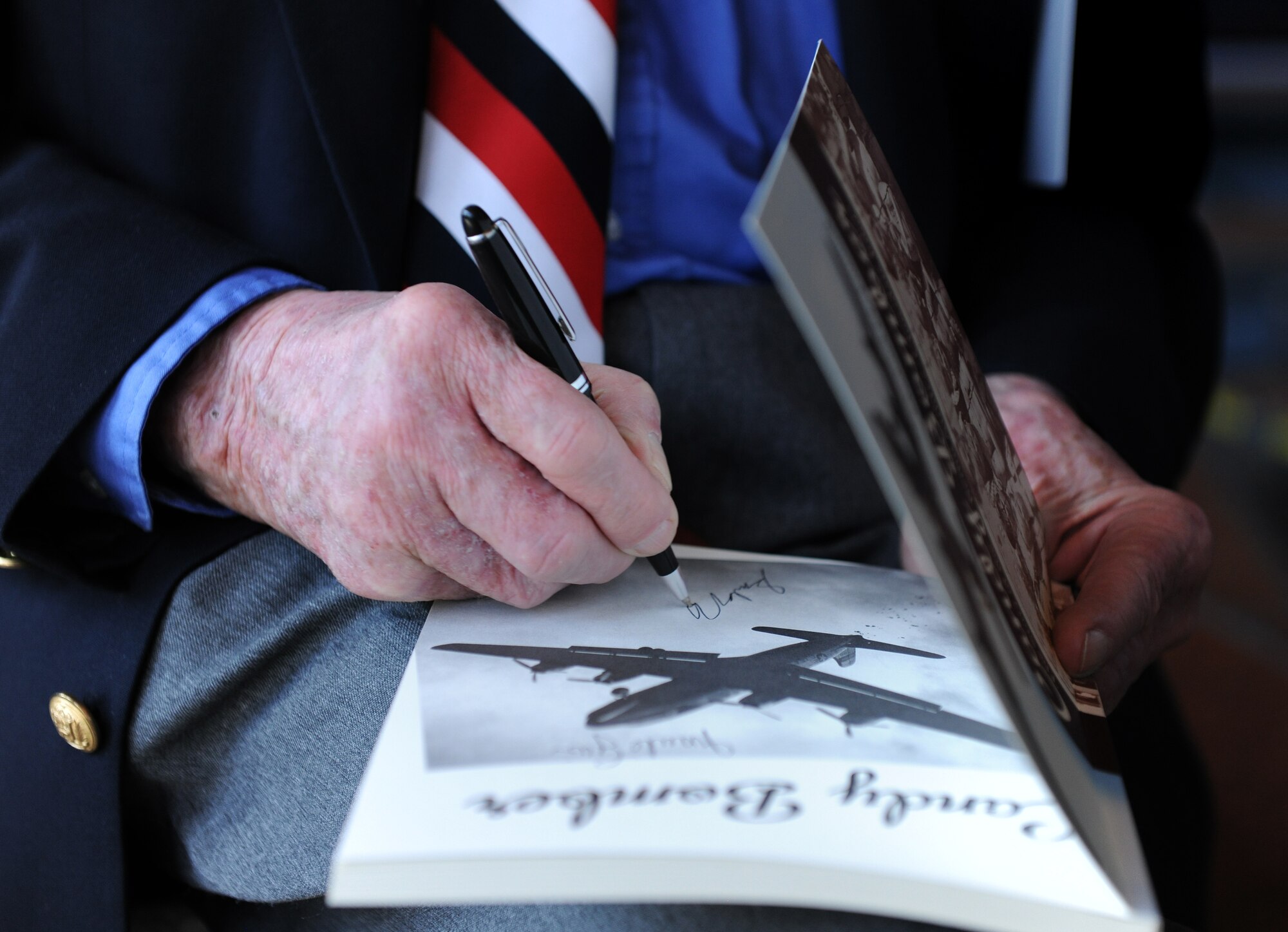SPANGDAHLEM AIR BASE, Germany – Retired Col. Gail Halvorsen signs a book for a Bitburg Middle School student during his visit here May 18. Colonel Halvorsen dropped candy to Berlin children from 1947-1948 and earned the nickname “Candy Bomber.” (U.S. Air Force photo/Senior Airman Nathanael Callon)