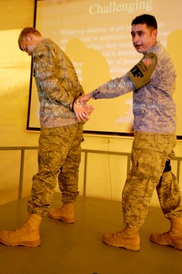 Staff Sgt. Juan Juarez, a training manager with a 387th Expeditionary Security Forces Squadron, educates force protection Airmen on the proper way to use zip ties as restraints. Sergeant Juarez as well as Tech. Sgt. Clint Organ are part of the revamped 387th ESFS training program that includes a mobile training unit that helps train defenders at their post. (U.S. Air Force photo by Staff Sgt. Patrice Clarke)