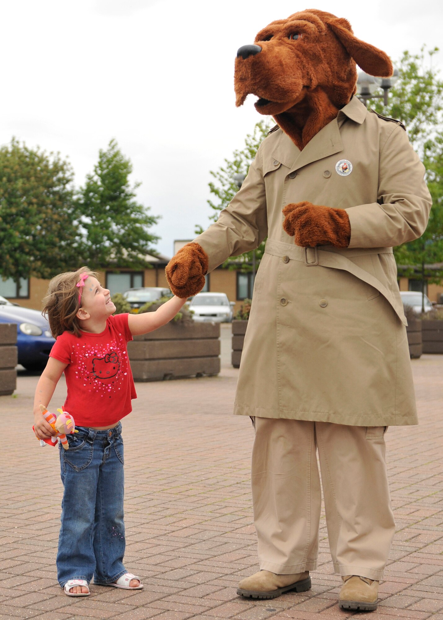 ROYAL AIR FORCE LAKENHEATH, England - McGruff the Crime Dog holds 4-year-old Lily Creach's hand at the RAF Lakenheath Commissary during National Police Week on May 17, 2011. Police week is held to honor all law enforcement officers for their dedication, sacrifice and service. McGruff and 48th Security Forces Squadron Airmen met shoppers, provided a weapons display and offered finger-printing. (U.S. Air Force photo/Senior Airman Tiffany M. Deuel)