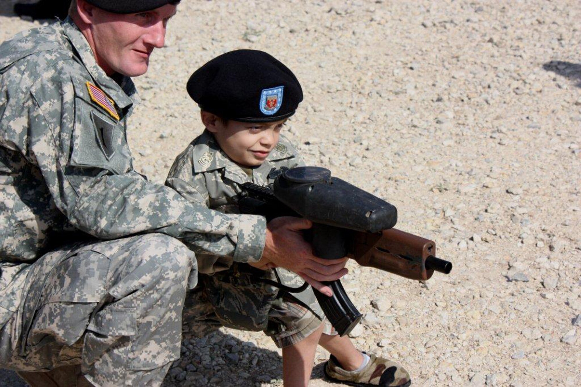 GOODFELLOW AIR FORCE BASE, Texas – Army Sgt. 1st Class Shaun Kuhn, 344th Military Intelligence Battalion, shows 8-year-old Shawn Chavez how to work a paintball gun during his tour at Camp Sentinel May 18.  Shawn also toured the Afghan Village, the fire academy and saw a military working dog demonstration during his visit to the base. Servicemembers from the Army, Air Force Navy and Marine Corps hosted Shawn and his family as part of the young boy's wish to meet a Soldier.  (U.S. Army photo/Staff Sgt. Michael Carlson)