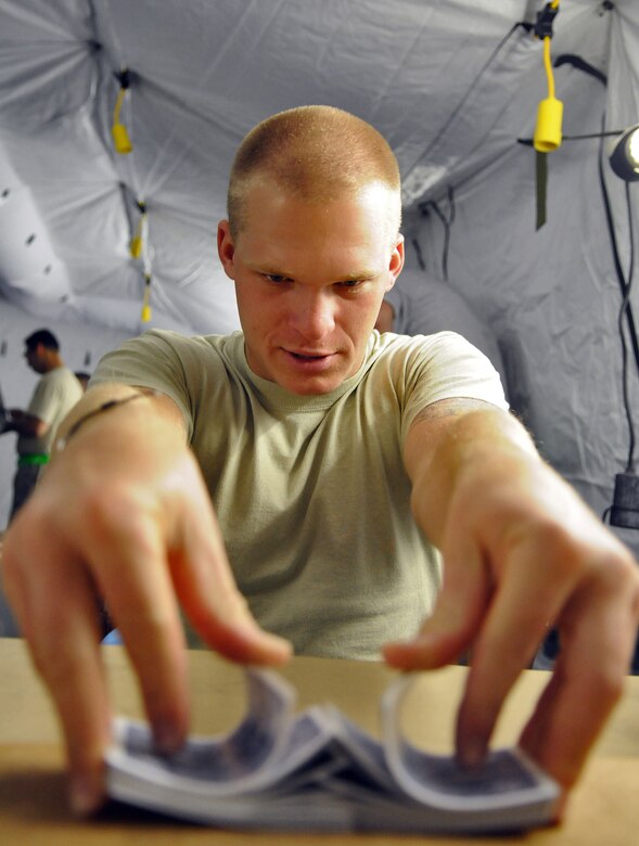 GEROLSTEIN, Germany –Airman 1st Class Derek Paterson, 606th Air Control Squadron radio frequency transmission systems journeyman, shuffles cards during some downtime during exercise Eifel Thunder 2011 here May 10. The 606th ACS participated in a field exercise that tested their ability to deploy and set up a deployed radar and satellite communications site as well as everything else required to accomplish their mission. The squadron returned to Spangdahlem Air Base May 16. (U.S. Air Force photo/Senior Airman Nick Wilson)