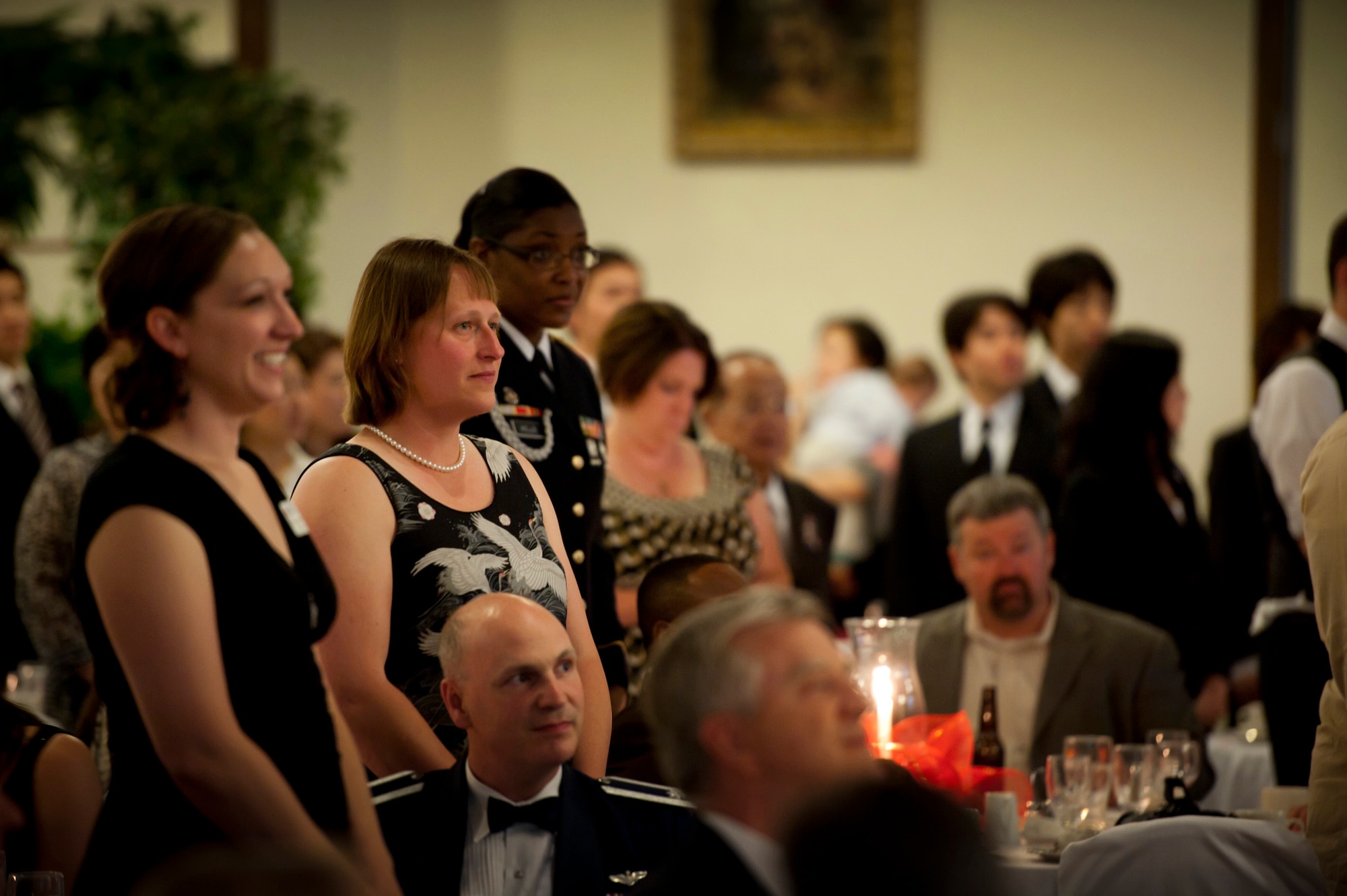YOKOTA AIR BASE, Japan -- American Red Cross volunteers stand to be recognized by the assembled audience at the Red Cross Appreciation Dinner at Yokota Air Base, Japan, May 18, 2011. (U.S. Air Force photo/Staff Sgt. Samuel Morse)