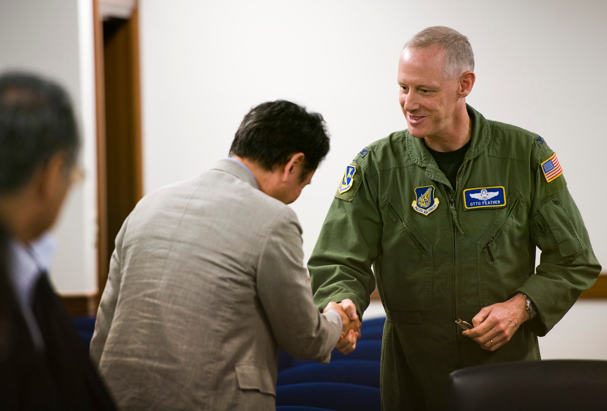 YOKOTA AIR BASE, Japan -- Col. Otto Feather, 374th Airlift Wing commander, shakes hands with a local mayor, welcoming him to Yokota Air Base, Japan, May 18, 2011. Mizuho Town hosted an annual conference of mayors from the Tokyo area, and asked to bring them to Yokota Air Base to learn more about the U.S. Air Force's role in southern Japan. (U.S. Air Force photo/Staff Sgt. Samuel Morse)