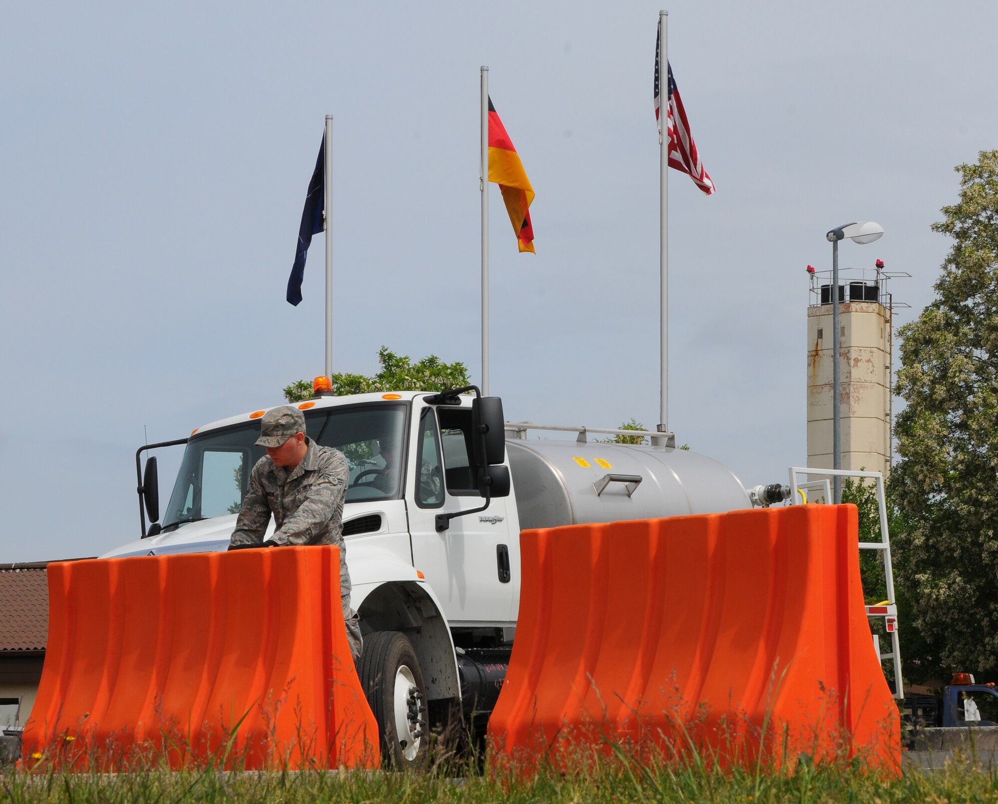 SPANGDAHLEM AIR BASE, Germany – Airman 1st Class Jeremy Robinson, 52nd Civil Engineer Squadron, sets a plastic barrier in place before it is filled with water during a barrier plan exercise here May 17. The barrier plan is conducted biannually to ensure Spangdahlem is capable of responding to increased threat levels. (U.S. Air Force photo/Airman 1st Class Dillon Davis)