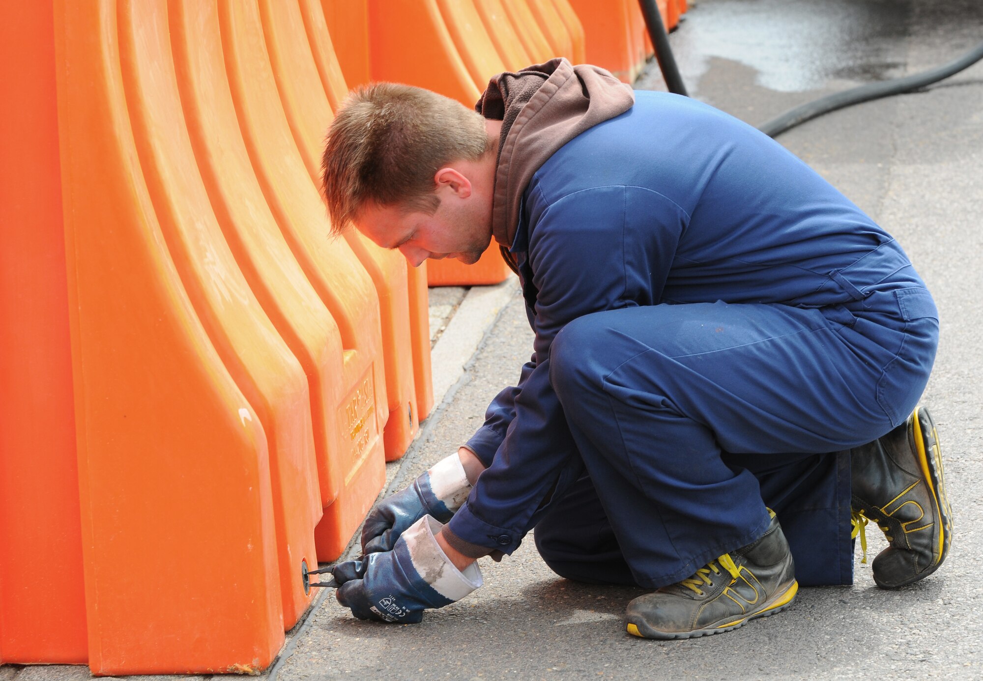 SPANGDAHLEM AIR BASE, Germany – Maik Neises, 52nd Civil Engineer Squadron civilian contractor, closes a drain hole on a plastic barrier during a barrier plan exercise here May 17. The barrier plan is conducted biannually to ensure Spangdahlem is capable of responding to increased threat levels. (U.S. Air Force photo/Airman 1st Class Dillon Davis)