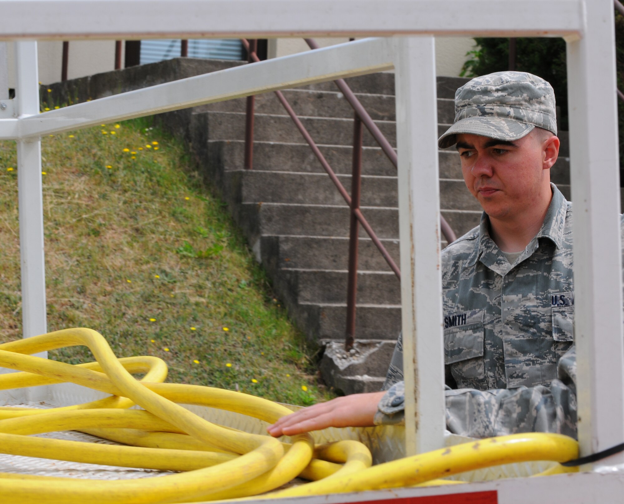 SPANGDAHLEM AIR BASE, Germany – Airman 1st Class Jacob Smith, 52nd Civil Engineer Squadron, takes a hose from a water truck during a barrier plan exercise here May 17. The barrier plan is conducted biannually to ensure Spangdahlem is capable of responding to increased threat levels.  (U.S. Air Force photo/Airman 1st Class Dillon Davis)