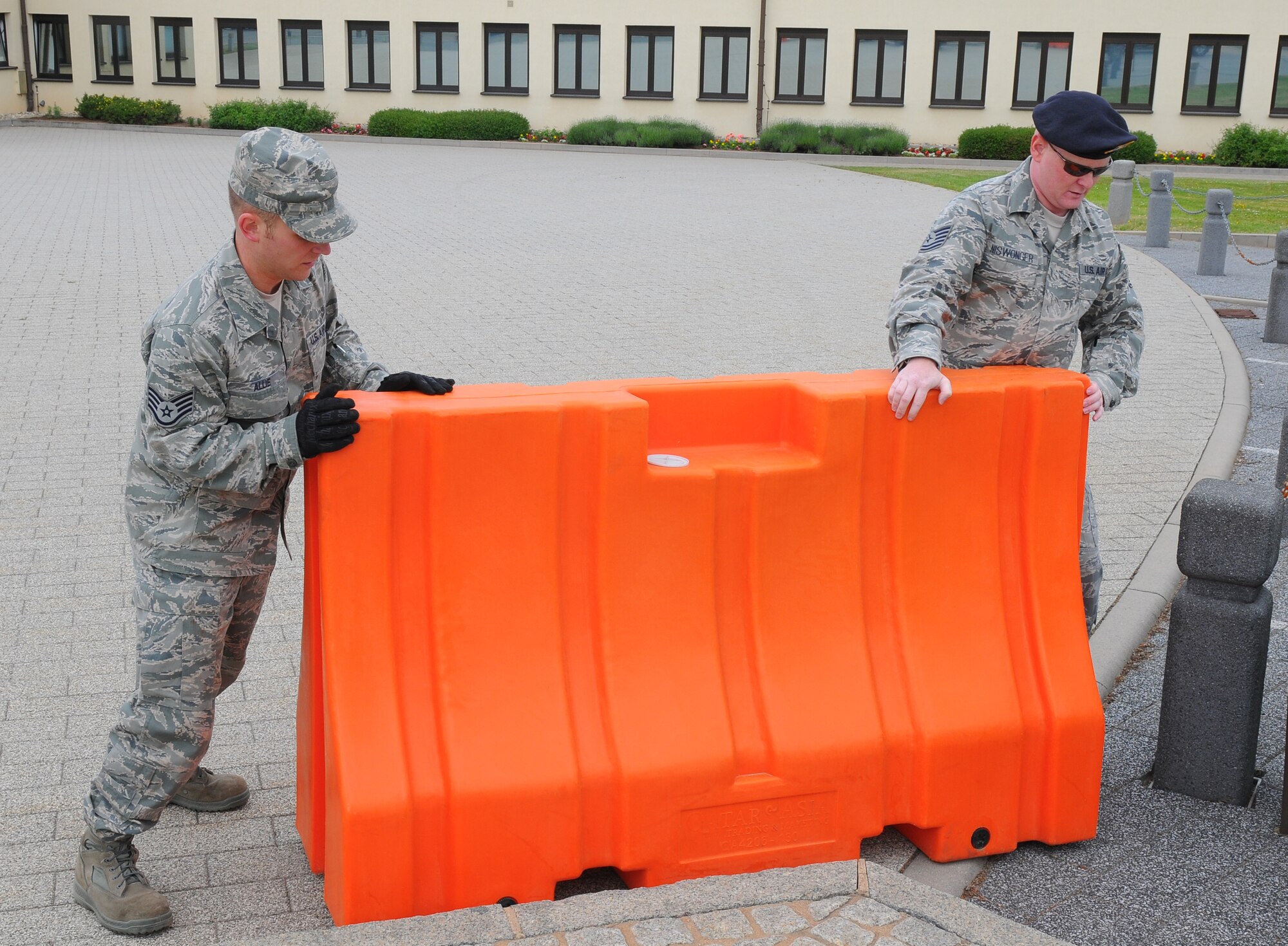SPANGDAHLEM AIR BASE, Germany – Staff Sgt. Kevin Allie, 52nd Logistics Readiness Squadron, and Tech. Sgt. Paul Niswonger, 52ndFighter Wing Anti-Terrorism Office, move a plastic barrier into place during a barrier plan exercise here May 17. The barrier plan is conducted biannually to ensure Spangdahlem is capable of responding to increased threat levels. (U.S. Air Force photo/Airman 1st Class Dillon Davis)
