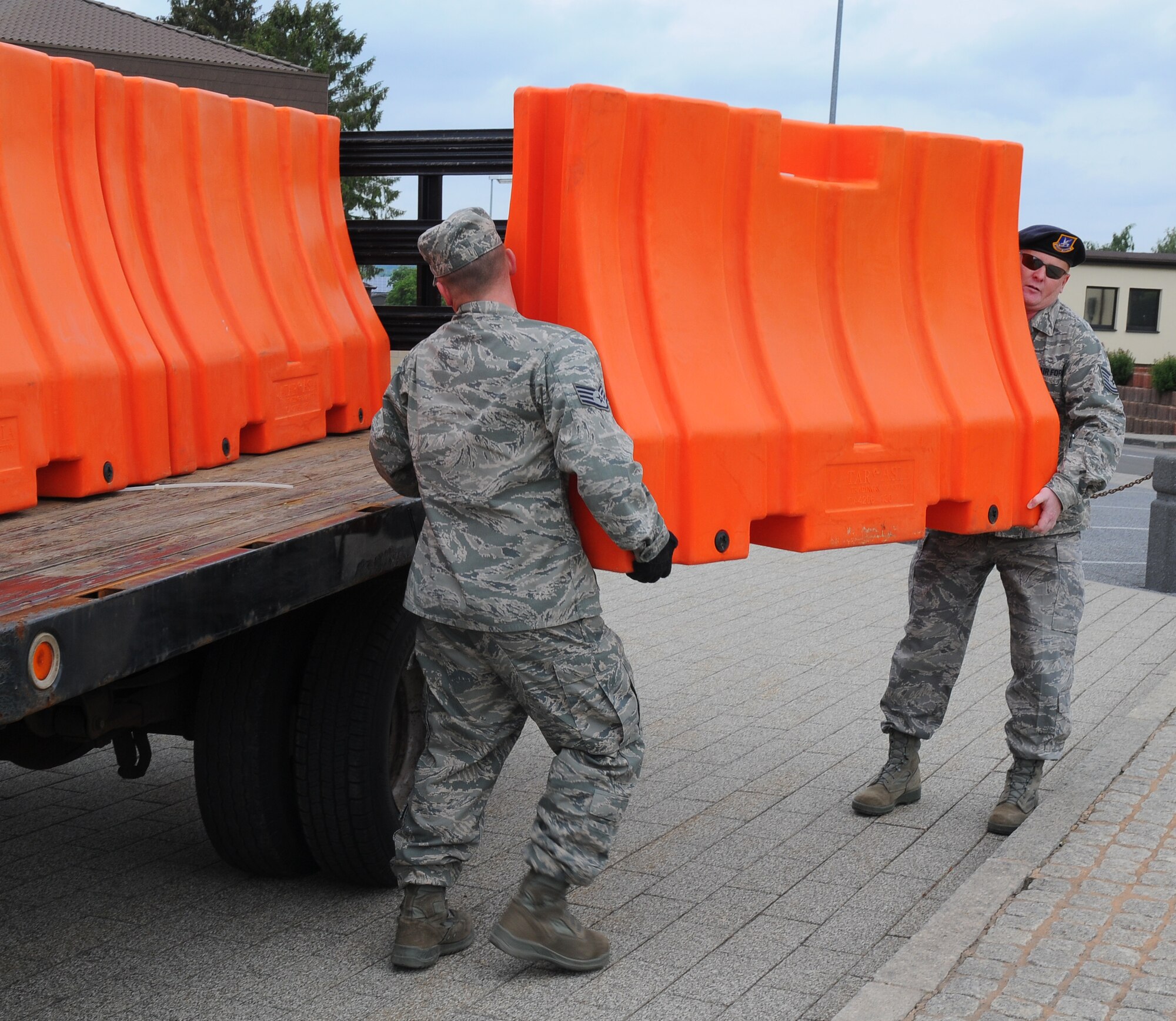 SPANGDAHLEM AIR BASE, Germany – Staff Sgt. Kevin Allie, 52nd Logistics Readiness Squadron, and Tech. Sgt. Paul Niswonger, 52ndFighter Wing Anti-Terrorism Office, unload a barrier from a transport vehicle during a barrier plan exercise here May17. The barrier plan is conducted biannually to ensure Spangdahlem is capable of responding to increased threat levels. (U.S. Air Force photo/Airman 1st Class Dillon Davis)