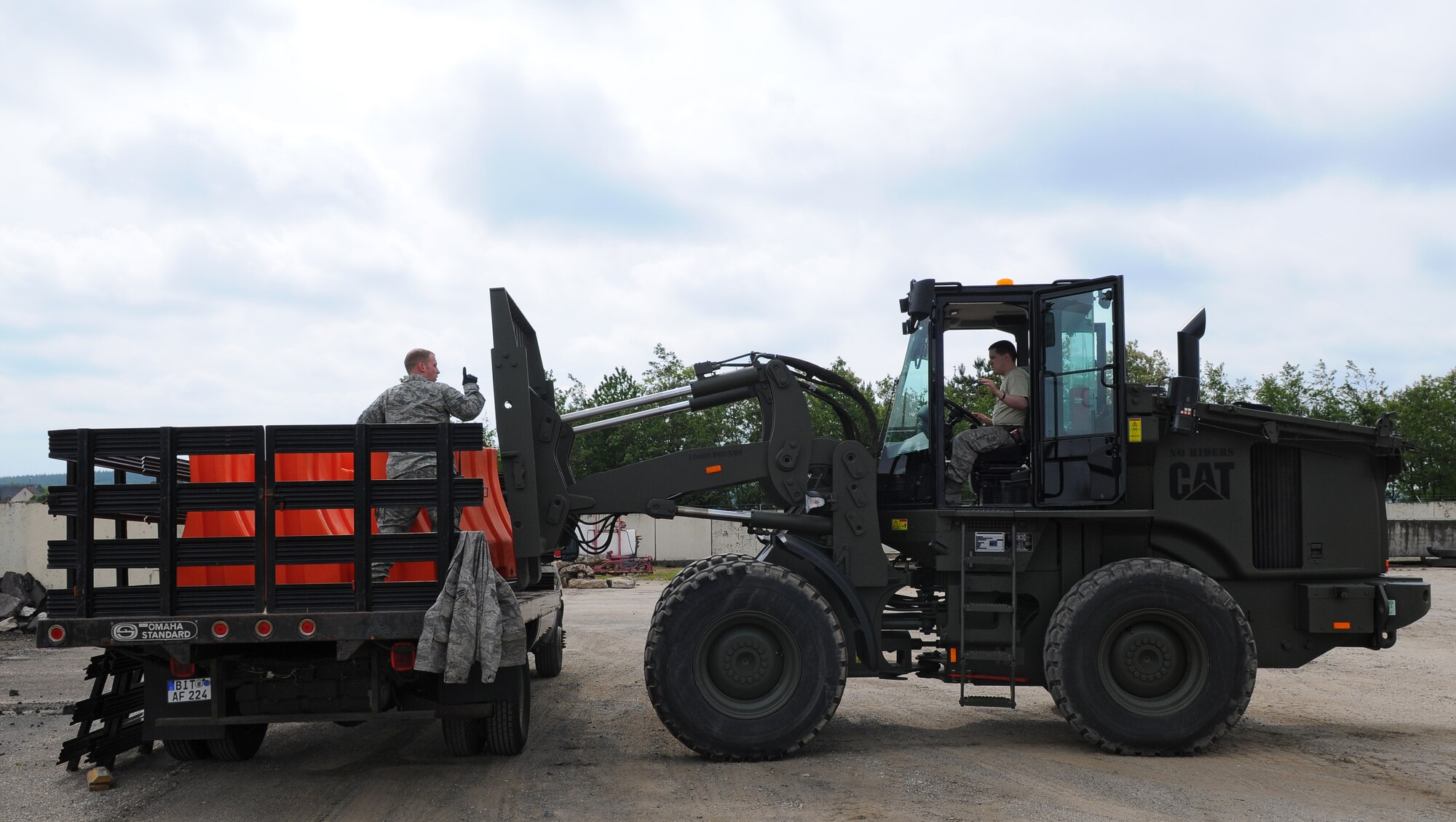 SPANGDAHLEM AIR BASE, Germany – Staff Sgt. Kevin Allie and Senior Airman Sam Wolverton, 52nd Logistics Readiness Squadron, load plastic barriers onto a transport vehicle during a barrier plan exercise here May 17. The barrier plan is conducted biannually to ensure Spangdahlem is capable of responding to increased threat levels. (U.S. Air Force photo/Airman 1st Class Dillon Davis)