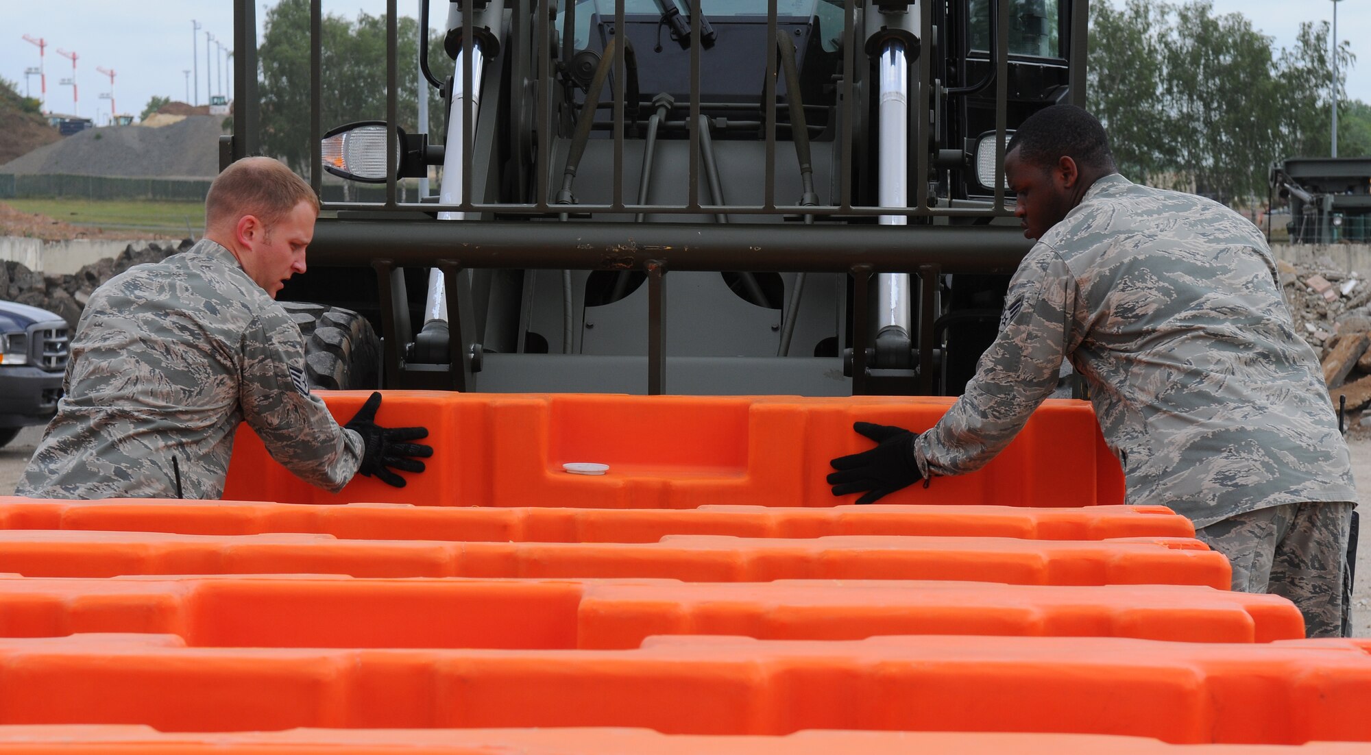 SPANGDAHLEM AIR BASE, Germany – Staff Sgt. Kevin Allie and Senior Airman Xavier Brown, 52nd Logistics Readiness Squadron, slide a plastic barrier onto a forklift during a barrier plan exercise here May 17. The barrier plan is conducted biannually to ensure Spangdahlem is capable of responding to increased threat levels. (U.S. Air Force photo/Airman 1st Class Dillon Davis)