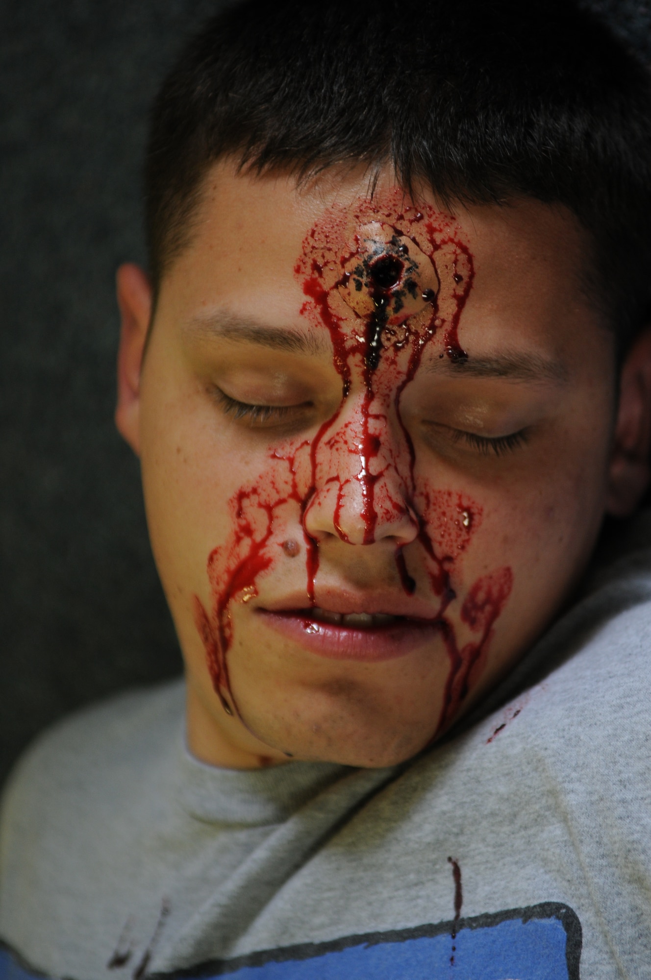 A volunteer plays the part of a gunshot wound victim after moulage is applied during Beverly High 11-4, a local readiness exercise at Kadena Air Base, Japan, May 19.  Kadena personnel are participating in this exercise to stay prepared for real world contingencies. (U.S. Air Force photo/Airman 1st Class Jarvie Z. Wallace)