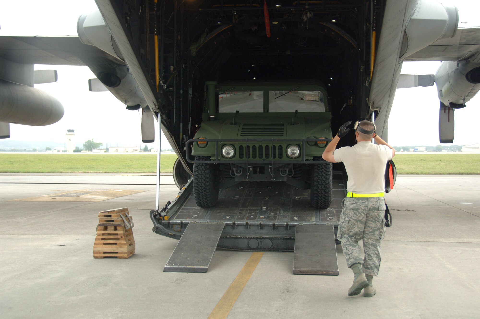 YOKOTA AIR BASE, Japan -- An air transportation craftsman from the 36th Airlift Squadron works as a guide to help Senior Airman James Branch, 36th AS air transportation craftsman, back a Humvee onto a C-130 plane here at Yokota May 17 during a practice run for the upcoming Air Mobility Command Rodeo. Joint base Lewis-McCord, Washington hosts the competition every two years to generate 'esprit de corps' and promote professionalism among and provide recognition for aircrews, maintenance, aerial port and security forces personnel. (U.S. Air Force photo/Airman 1st Class Lynsie Nichols)