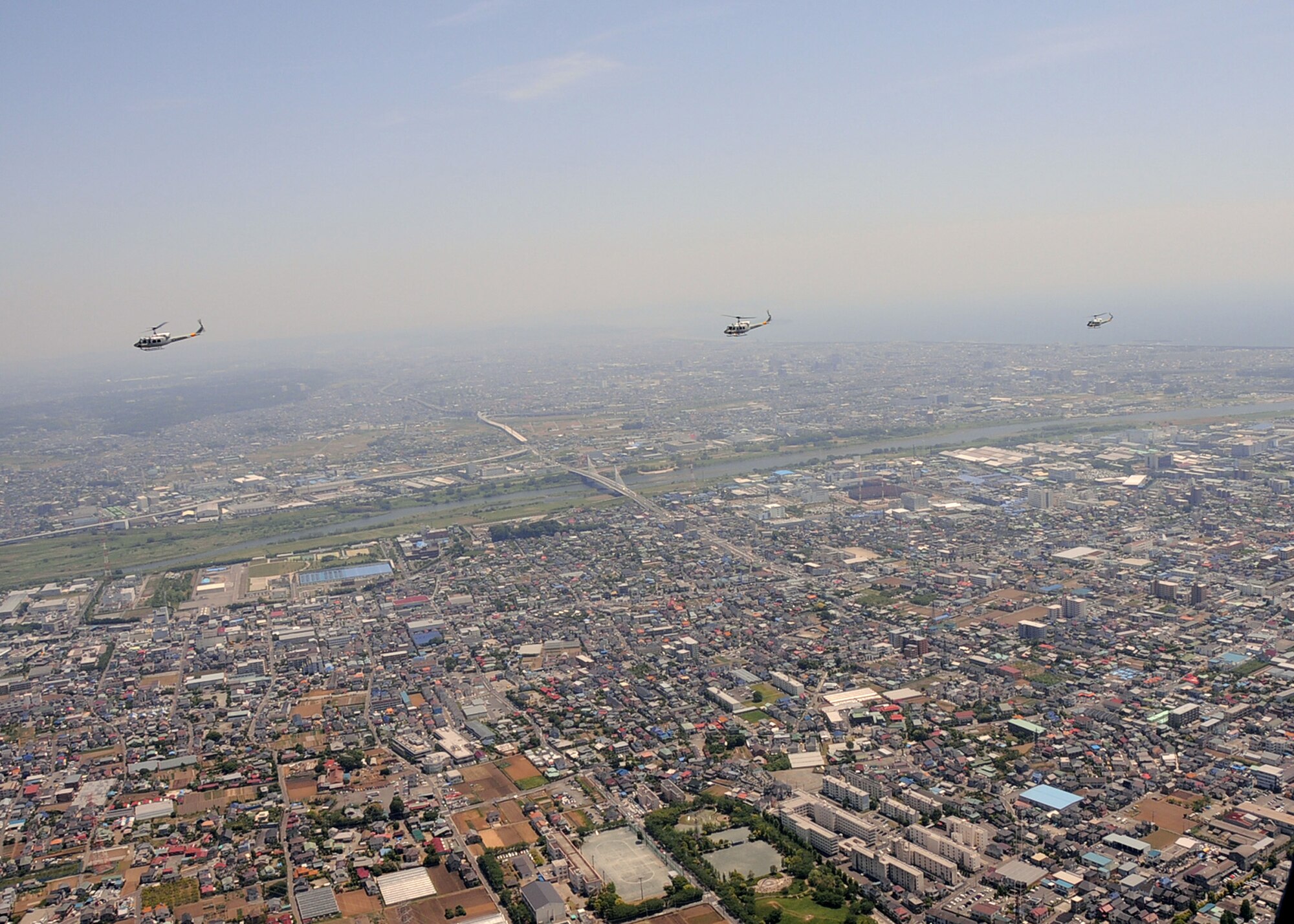 OVER JAPAN -- Three Yokota UH-1N Iroquois helicopters fly in-line above the Tokyo area during a four-ship "Huey" formation flight over Japan, May 19, 2011. The flight was a historic event for the 459th Airlift Squadron, flying all four UH-1Ns for the first time in nine years. A formation is not easy, but neither is being a good wingman, said Staff Sgt. Christopher Rector, 459th Airlift Squadron flight engineer. It takes practice and concentration to look after each other on and off duty. Yesterday, we were given the opportunity to look after each other in the sky, and we executed the mission flawlessly. (U.S. Air Force photo/Senior Airman Andrea Salazar)