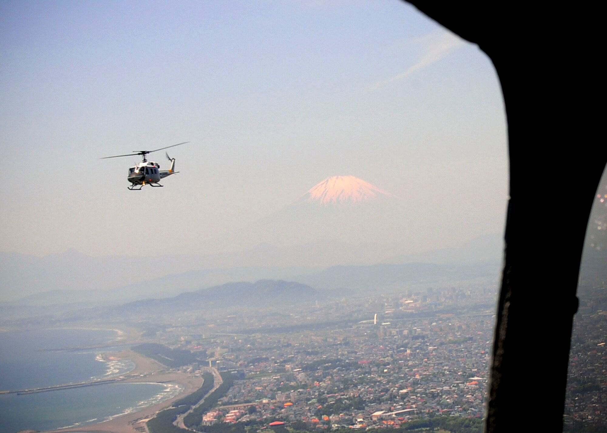 OVER JAPAN -- A UH-1N Iroquois helicopter flies above the Tokyo area during a four-ship "Huey" formation flight near Mt. Fuji, May 19, 2011. For Yokota, this was an opportunity for the base to see all four aircraft in-flight together since 2002, and also a chance for some of the newest aircrew members to experience how the Air Force's wingman culture translates to formation flight. (U.S. Air Force photo/Senior Airman Andrea Salazar)