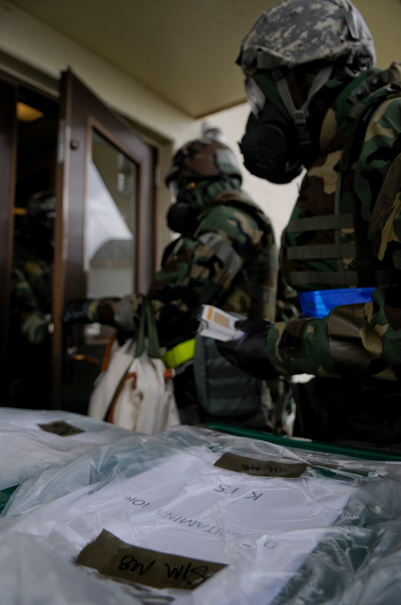 Airmen from the 18th Aircraft Maintenance Squadron practice decontamination procedures while in mission-oriented protective posture gear before entering a building during Beverly High 11-4, a local operational readiness exercise, on Kadena Air Base, May 19. During the LORE, Airmen were expected to perform and operate in numerous scenarios from power outages and minor on-the-job injuries, to bomb threats and chemical attacks. (U.S. Air Force photo/ Airman 1st Class Maeson L. Elleman)