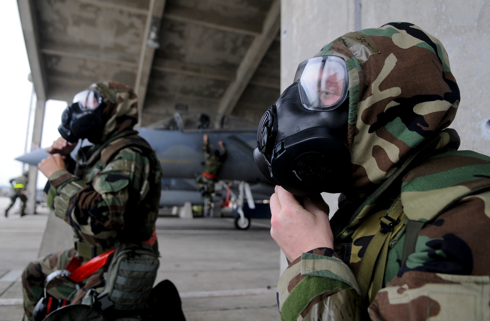 Airmen from the 67th Aircraft Maintenance Unit scramble to protect themselves and equipment during a simulated aerial attack as part of Beverly High 11-4, a local operational readiness exercise, on Kadena Air Base, May 19. During the LORE, Airmen were expected to perform and operate in numerous scenarios from power outages and minor on-the-job injuries, to bomb threats, and aerial attacks. (U.S. Air Force photo/ Airman 1st Class Maeson L. Elleman)