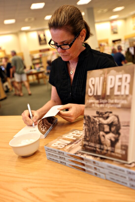 JACKSONVILLE, N.C.—Gina Cavallaro, author of Sniper: American Single-Shot Warriors in Iraq and Afghanistan and staff writer with the Marine Corps Times, signs a copy of her book to help with the Museum of the Marine during its book fair and living history display at Barnes and Noble, May 21.  The museum is attempting to raise enough funds for it to begin construction this spring.