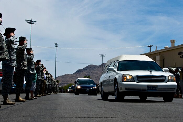 NELLIS AIR FORCE BASE, Nev.-- Airmen render salutes as a a hearse carrying U.S. Army Sgt. Ken Hermogino departs Nellis Air Force Base following a dignified transfer ceremony here May 21.  Sergeant Hermogino died May 9 in Herat province, Afghanistan, of injuries sustained in a non-combat related vehicle accident. The son of a retired U.S. Navy senior chief petty officer, Sergeant Hermogino graduated from Basic High School in Las Vegas in 1998 and, prior to transitioning to the U.S. Army in 2009, he served eight years in the U.S. Air Force as a medical administrator. Sergeant Hermogino was assigned to the 7th Squadron, 10th Cavalry Regiment, 1st Brigade Combat Team, 4th Infantry Division, Fort Carson, Colo. He will be laid to rest with full military honors at the Southern Nevada Veterans Memorial Cemetery in Boulder City. (U.S. Air Force photo/Senior Airman Brett Clashman)