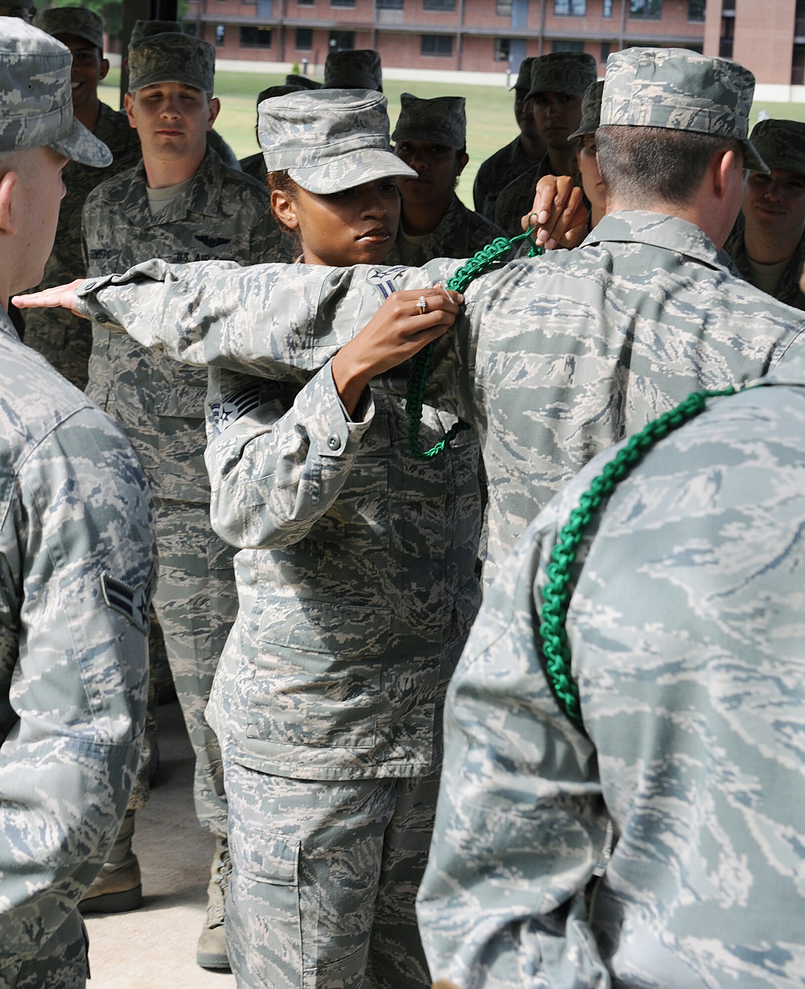 Staff Sgt. CheLeta Brown, 714th Training Squadron Military Training Leader flight chief, pins on a green rope May 13, 2011 on Little Rock Air Force Base, Ark. The MTLs choose Airmen who show leadership potential to perform as element leaders. (U.S. Air Force photo/Airman 1st Class Ellora Stewart)