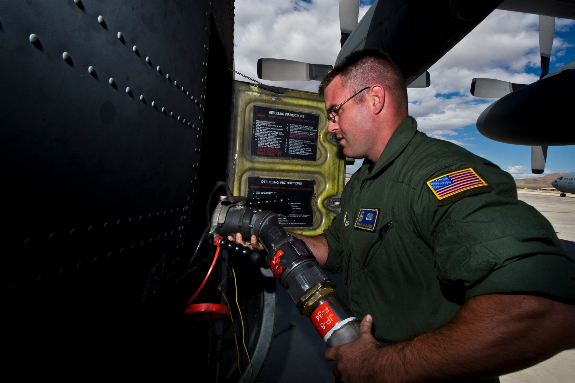 U.S. Air Force Senior Airman Ryan Sluss a crew chief from the 50th Airlift Squadron, Little Rock Air Force Base, Ark., attaches a fuel pump to a C-130 Hercules at Nellis AFB, Nev., following a Mobility Air Forces Exercise May 18. Approximately 40 C-17 Globemaster III and C-130 aircraft assembled in aerial formations over the Nevada Test and Training Range to conduct air and ground operations as part of the bi-annual, U.S. Air Force Weapons School training event. (U.S. Air Force photo/Senior Airman Brett Clashman)
