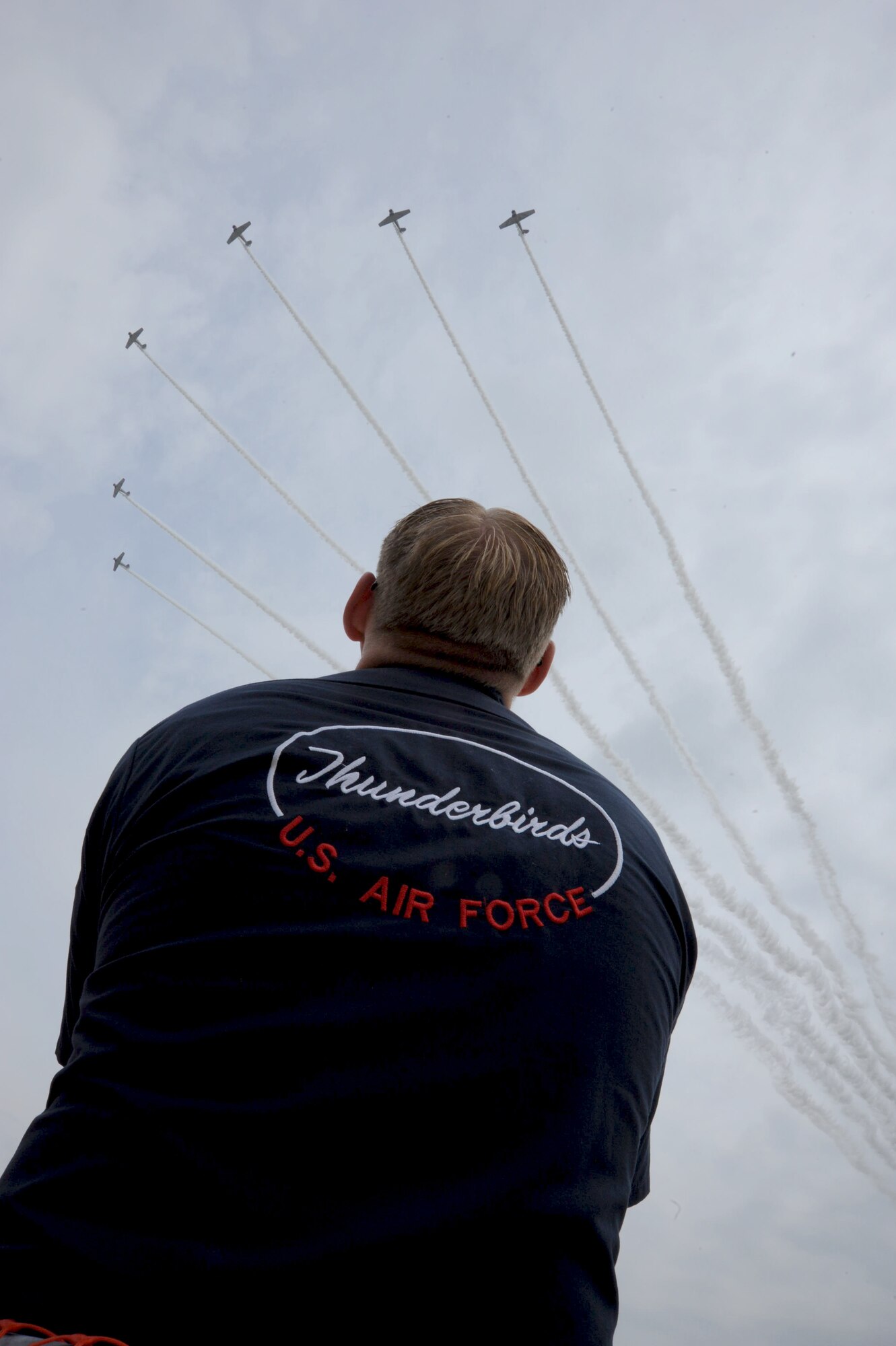 A supprt crewmember for The U.S. Air Force Thunderbirds looks on as the Geico Skytypers message the guests at the 2011 Joint Service Open House at Joint Base Andrews, Md, May 20. JSOH affords the public an opportunity to meet the men and women of the Armed Forces and to see military equipment through the efforts of active duty, guard and reserve service members, as well as civilians employees, retirees and family members. (U.S. Air Force photo by Benjamin Newell)