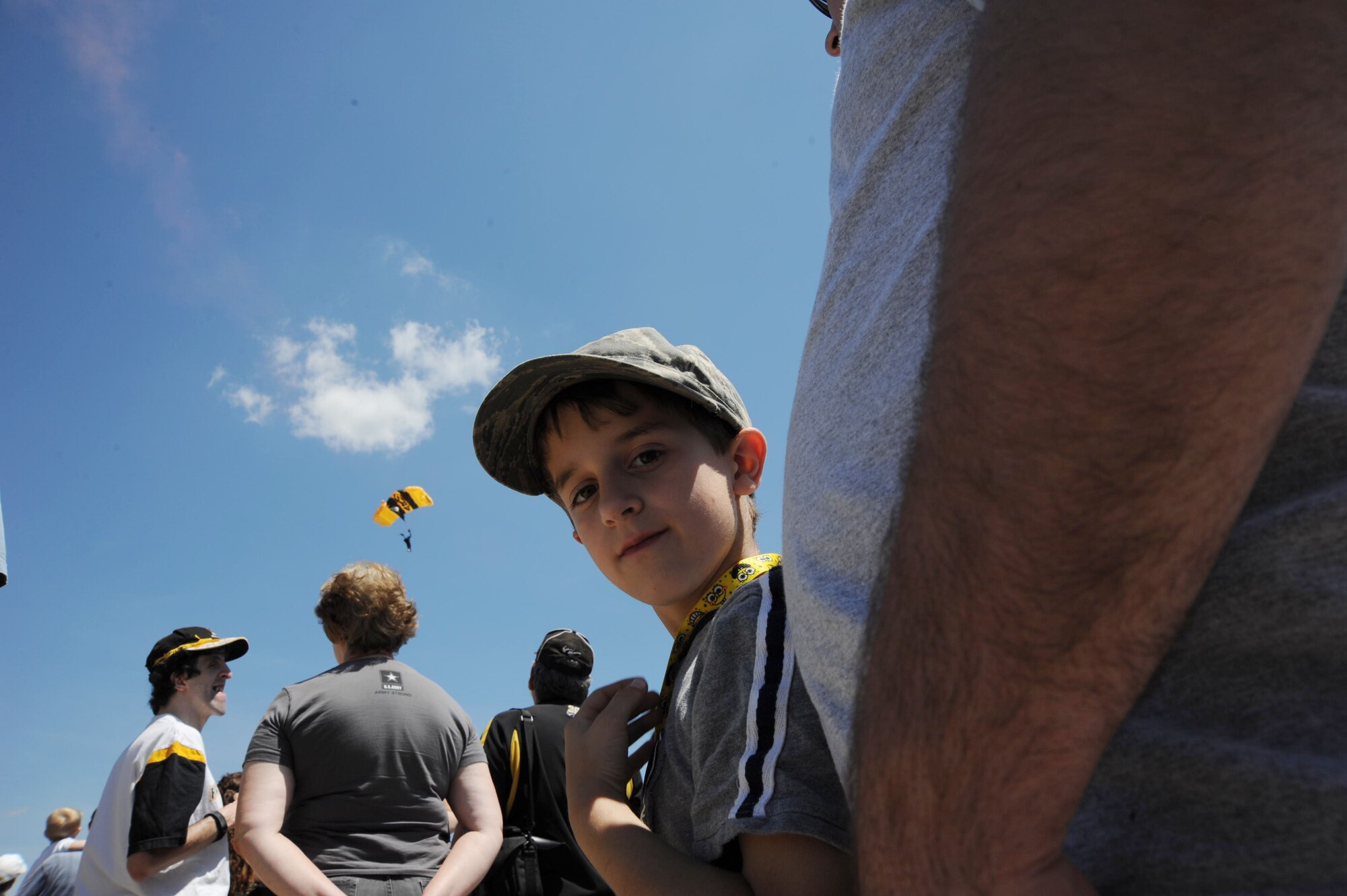 8-year-old Jacob Smith of Glen Burnie, Md., stands under his dad, Mike Wilson's, shadow as a soldier of The U.S. Army Golden Knights descends from the skies over Joint Base Andrews, Md. during the 2011 Joint Service Open House May 21. JSOH affords the public an opportunity to meet the men and women of the Armed Forces and to see military equipment through the efforts of active duty, guard and reserve service members, as well as civilians employees, retirees and family members. (U.S. Air Force photo by Benjamin Newell)