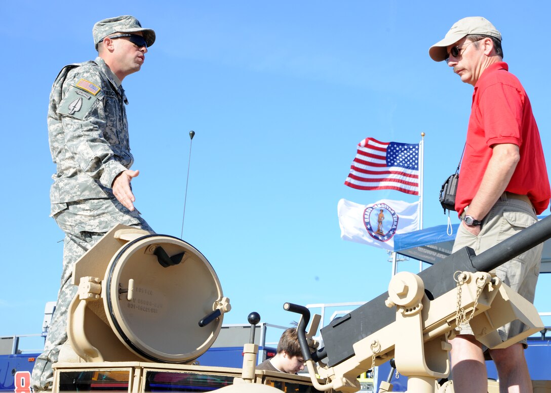 Army Staff Sgt. Brain Deschenes 2nd Battalion, 8th Calvary Tank Commander, Fort Hood, Texas, explains the capabilites of the M1A1 Abrams Tank to David Harpster, Boyscout 32 Troop leader, during the 2011 Joint Service Open House May 21. The JSOH affords the public an opportunity to meet the men and women of the Armed Forces and to see military equipment from the Navy, Marines, Army, Air Force, and Coast Guard. The JSOH is planned and conducted through the efforts of active duty, guard and reserve service members, as well as civilian employees, retirees and family members.(U.S. Air Force photo by Senior Airman Matt Coleman-Foster)
