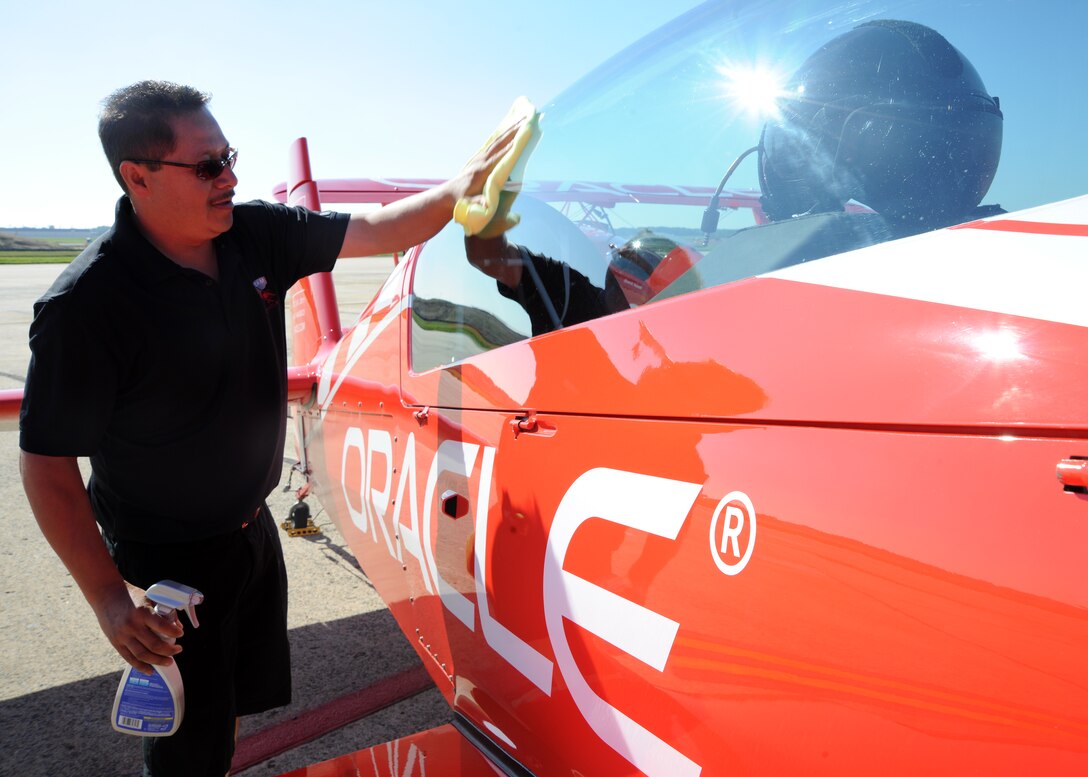 Jose Serban, Team Oracle mechanic, wipes down Team Oracles prop aircraft canopy before its flight May 21 at the 2011 Joint Service Open House here. The JSOH affords the public an opportunity to meet the men and women of the Armed Forces and to see military equipment from the Navy, Marines, Army, Air Force and Coast Guard. The JSOH is planned and conducted through the efforts of active duty, guard, and reserve servicemembers, as well as civilian employees, retirees and family members. (U.S. Air Force photo by Senior Airman Matt Coleman-Foster)