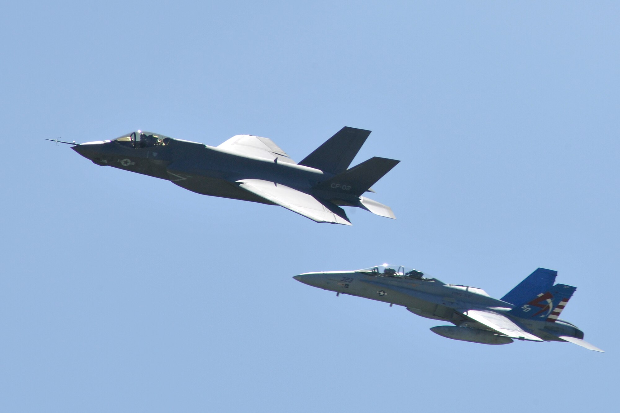 A Navy F-18 Hornet escorts the new Navy variant of the F-35 Lightning II as they fly over the crowd during the 2011 Joint Service Open House at Joint Base Andrews, Md., May 21. This is the first time this aircraft has performed at a public event of this nature. The JSOH affords the public an opportunity to meet the men and women of the Armed Forces and to see military equipment through the efforts of active duty, guard and reserve servicemembers, as well as civilians employees, retirees and family members. (U.S Air Force photo by Senior Airman Melissa V. Brownstein)