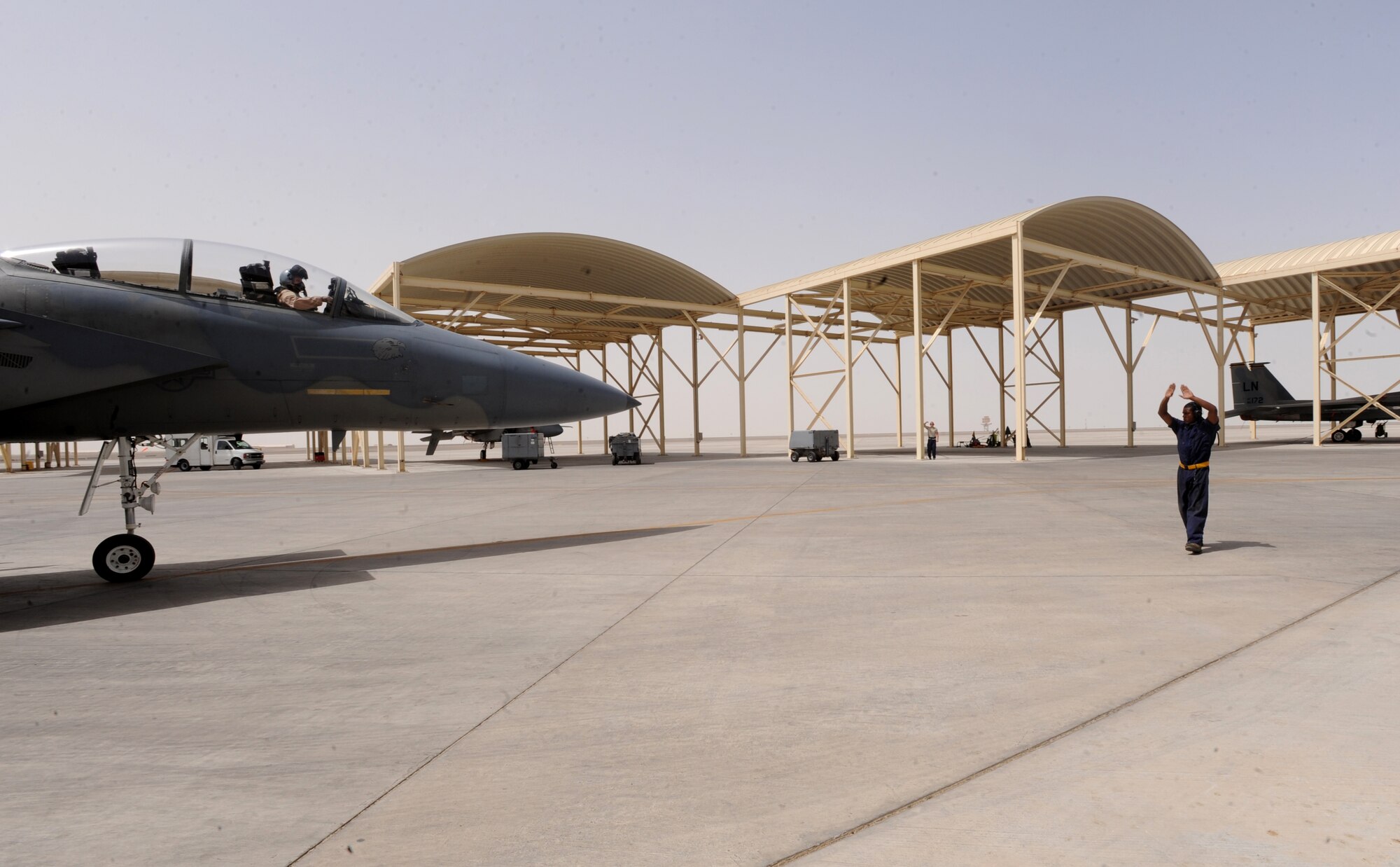 Airman Brian Carter, 380th Expeditionary Aircraft Maintenance Squadron, gives the pilot directions as he pulls out of the F-15C Eagle's shelter May 3, 2011. The F-15 Eagle is an all-weather, extremely maneuverable, tactical fighter designed to permit the Air Force to gain and maintain air supremacy over the battlefield. Airman Carter is deployed from Lakenheath AB, U.K. (U.S. Air Force photo by Senior Airman Maynelinne De La Cruz)   