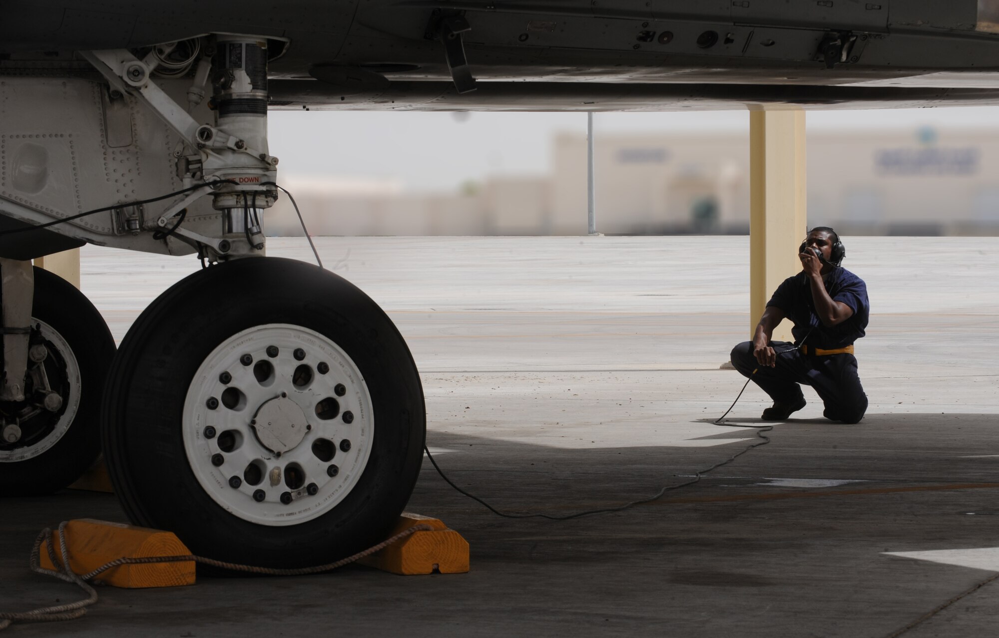 Airman Brian Carter, 380th Expeditionary Aircraft Maintenance Squadron, communicates with the pilot as he tests the controls of the wings on the F-15C Eagle aircraft May 3, 2011. It can detect and track aircraft and small high-speed targets at distances beyond visual range down to close range, and at altitudes down to treetop level. Airman Carter is deployed from Lakenheath AB, U.K. (U.S. Air Force photo by Senior Airman Maynelinne De La Cruz)  