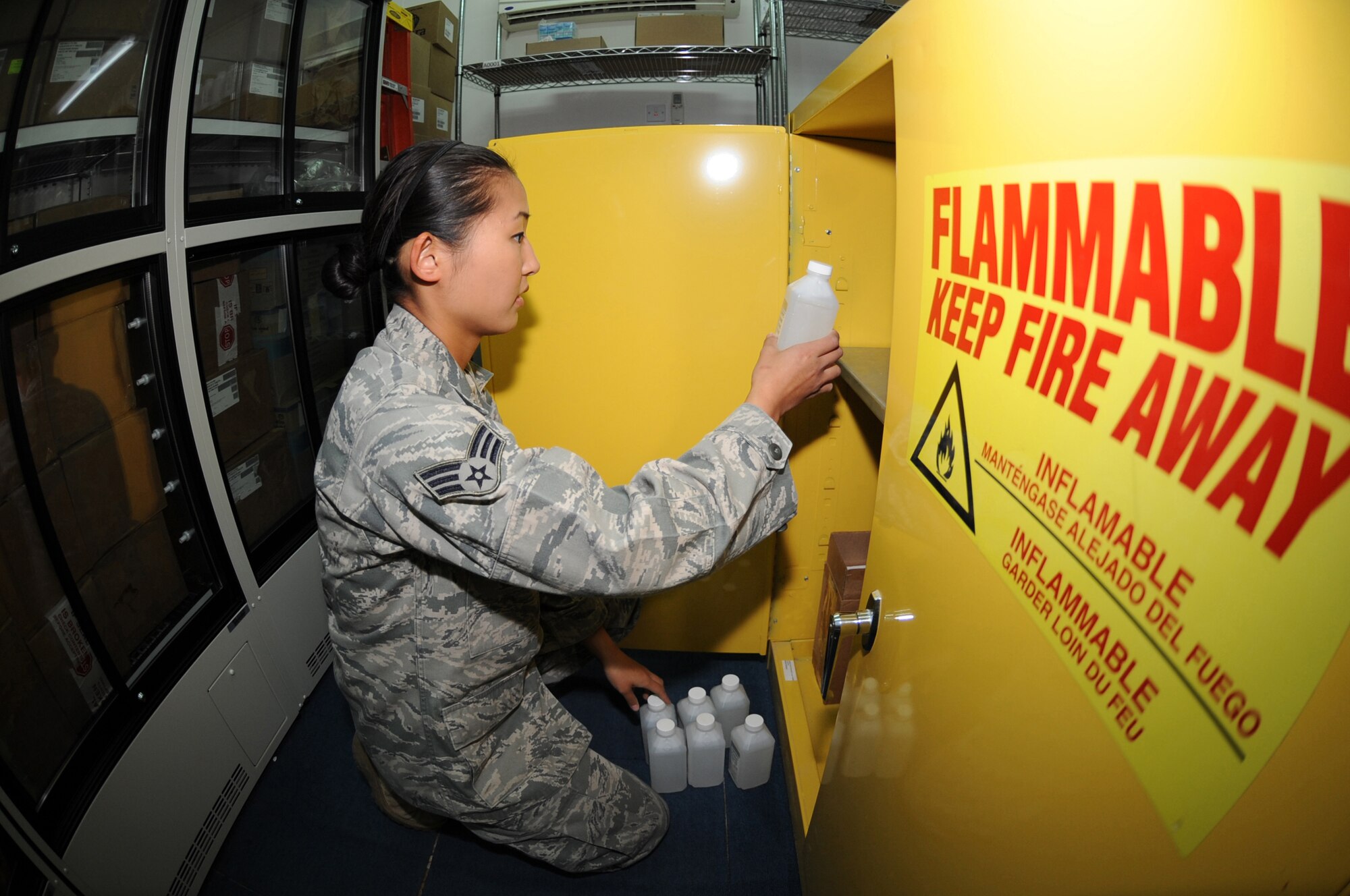 Senior Airman Lily Pak 380th Expeditionary Medical Group organizes the container in which all flammable products are kept, April 28, 2011. Some of these products include ethyl alcohol, hand sanitizer, and histofreezer kits. (U.S Air Force photo by Senior Airman Maynelinne De La Cruz)