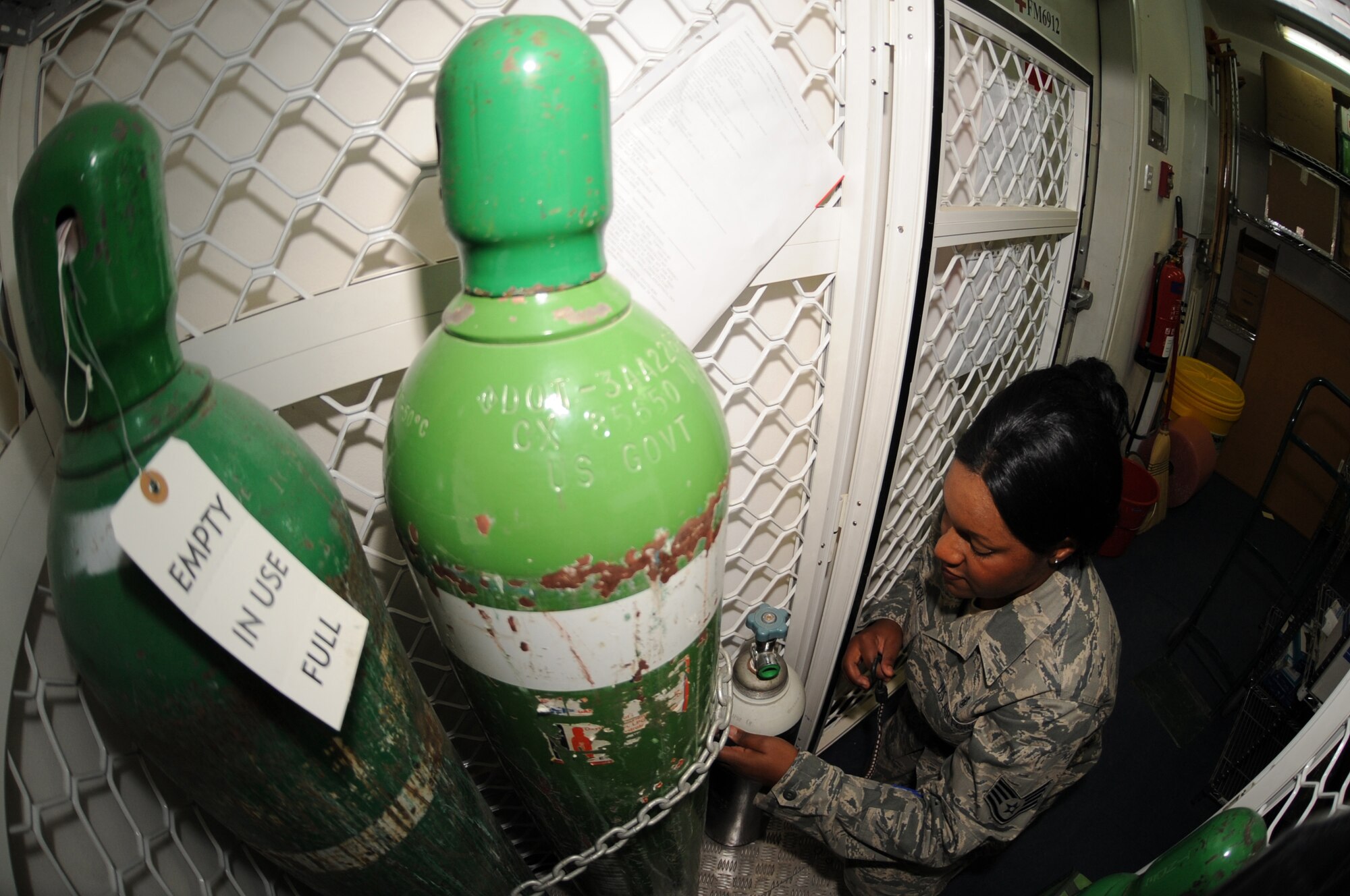 Staff Sgt. Laveena Pugh, 380th Expeditionary Medical Group, secures oxygen tanks to their upright position to prevent them from falling over April 28, 2011. Oxygen tanks are kept in the clinic and ambulances should there be an incident where a patient cannot breathe on their own. (U.S. Air Force photo by Senior Airman Maynelinne De La Cruz) 