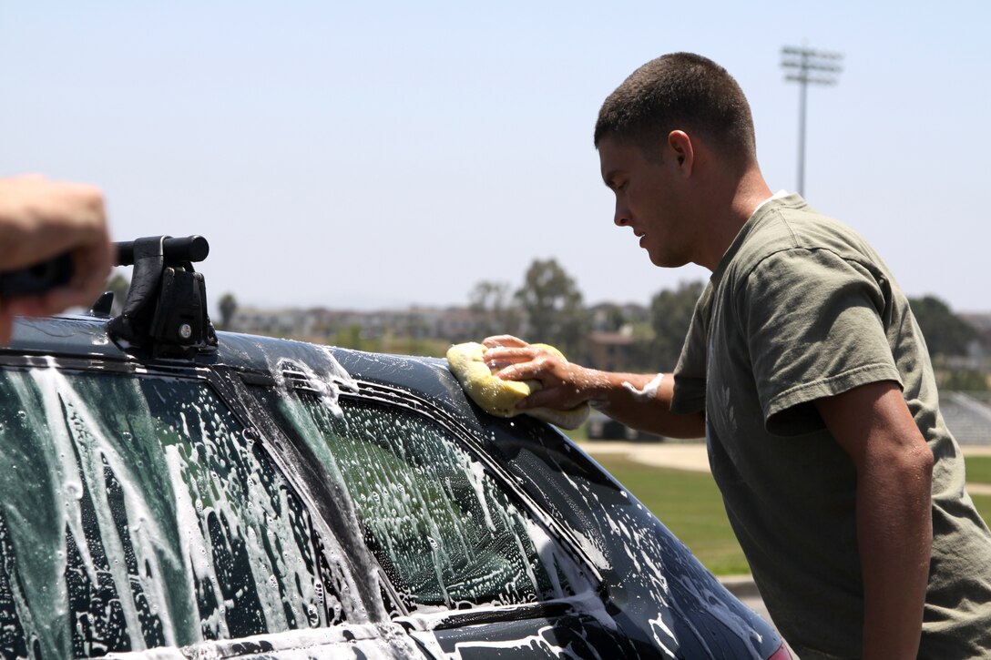 Lance Cpl. Zachary A. Gonzales,  a volunteer at the car wash and a field radio operator with the 15th Marine Expeditionary Unit (MEU)  washes a car on Camp Pendleton’s Main side to help raise money for Southern California Elite Gymnastics Academy (SCEGA), on May 21. Marines with the 15th MEU’s command element spent this Saturday volunteering on base at a car wash fundraiser for a gymnastics club. The event was an excellent opportunity for the unit’s service members to volunteer their time helping others.