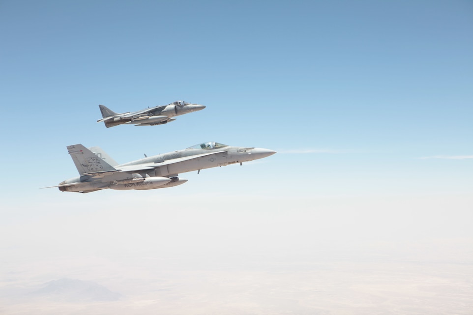 An F/A-18 Hornet from Marine Fighter Attack Squadron 122 and an AV-8B Harrier with Marine Attack Squadron 513 fly together after both completed aerial refueling in Helmand province, Afghanistan, May 22. VMFA-122 flew with VMA-513 during the first three days of the latter’s combat operations to help familiarize the Harrier squadron with the area of operations they would be flying over for the next several months.
