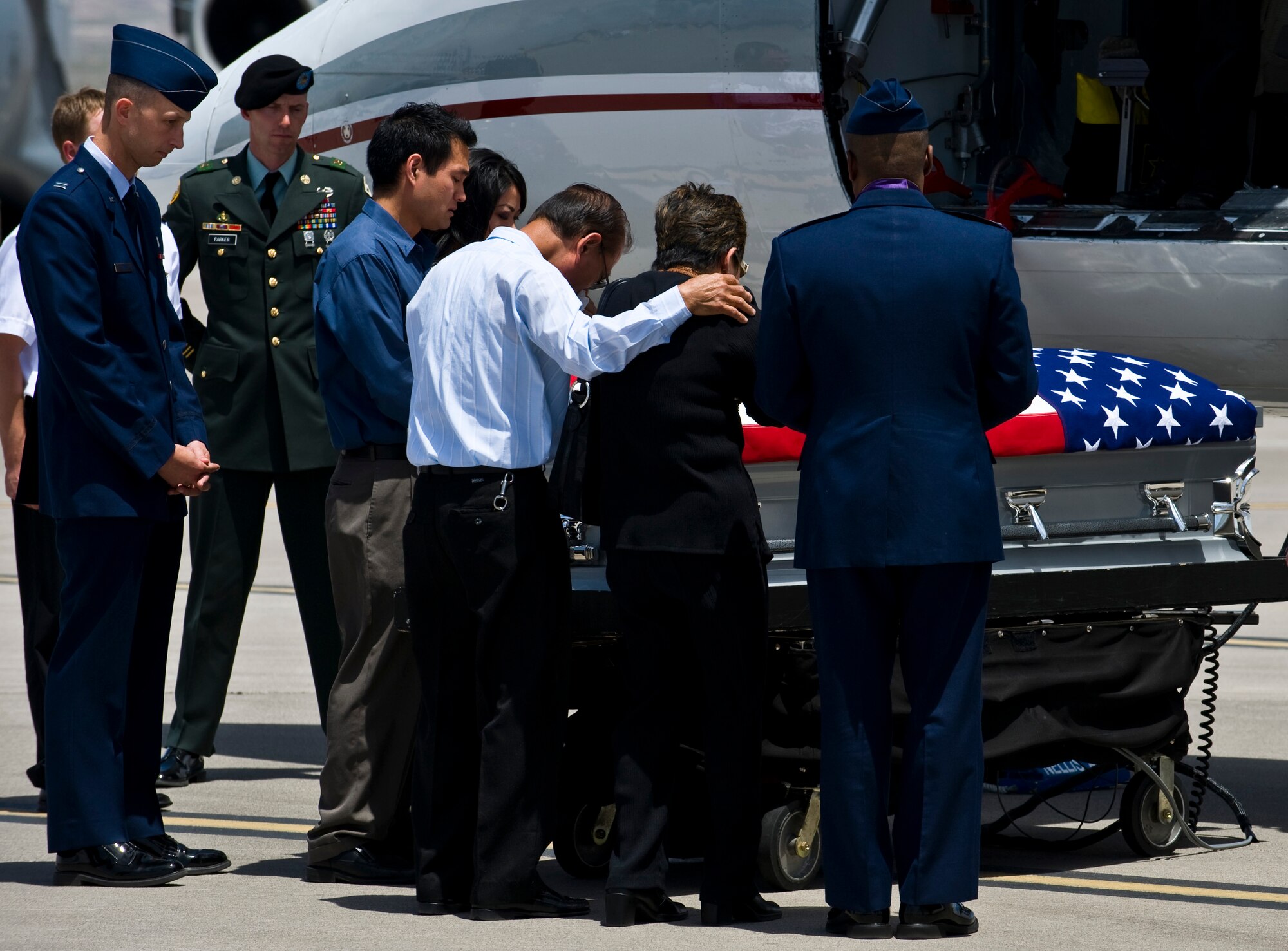 NELLIS AIR FORCE BASE, Nev.-Family members grieve during a dignified transfer ceremony for U.S. Army Sgt. Ken Hermogino at Nellis Air Force Base, May 21, 2011. Sergeant Hermogino died May 9 in Herat province, Afghanistan, of injuries sustained in a non-combat related vehicle accident. Sergeant Hermogino graduated from Basic High School in Las Vegas in 1998 and, prior to transitioning to the U.S. Army in 2009, he served eight years in the U.S. Air Force as a medical administrator. He will be laid to rest with full military honors at the Southern Nevada Veterans Memorial Cemetery in Boulder City. (U.S. Air Force photo/Senior Airman Brett Clashman)