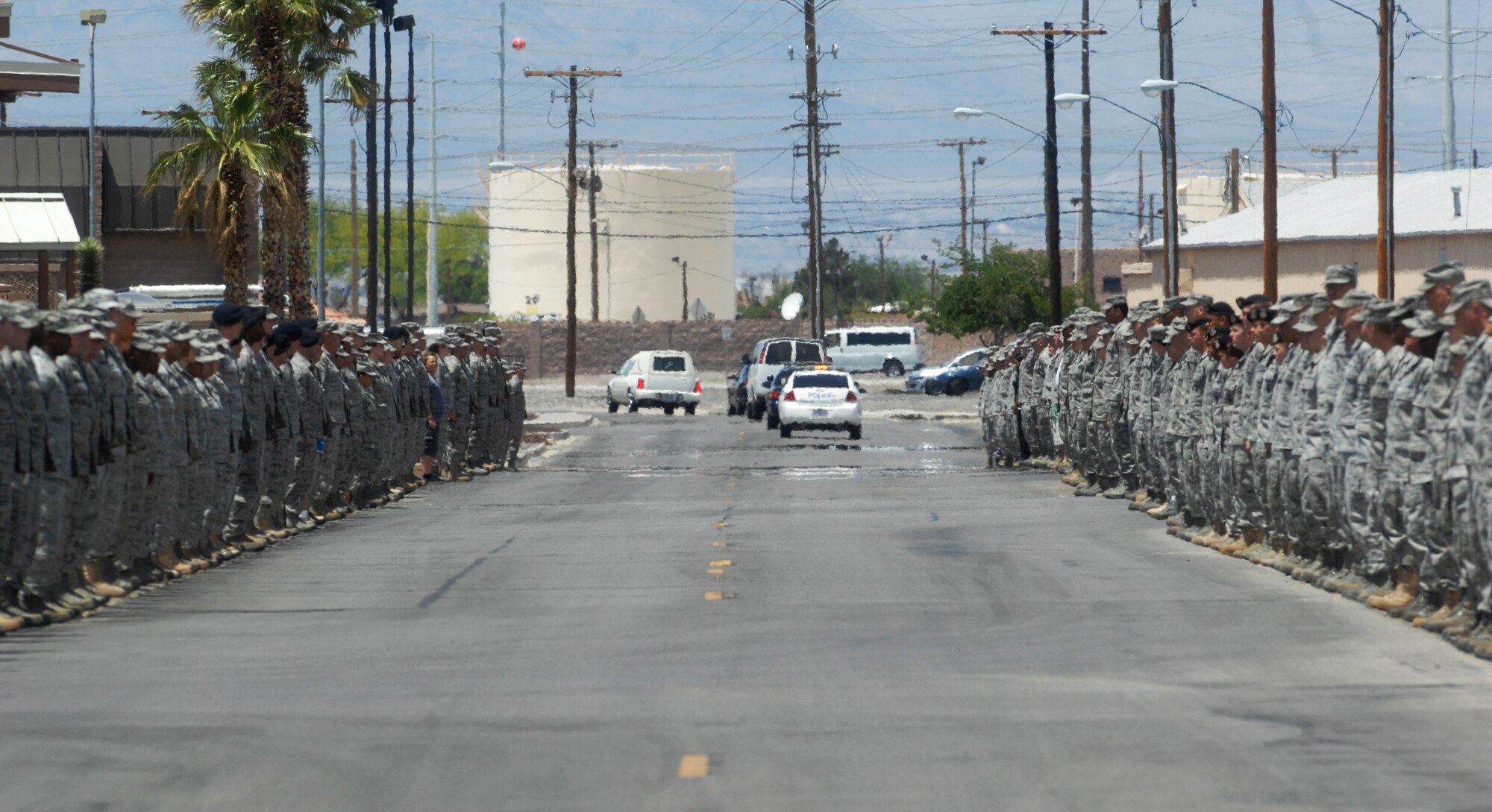 NELLIS AIR FORCE BASE, Nev.-- Airmen line the streets of Nellis Air Force Base to to pay their respects as a a hearse carrying U.S. Army Sgt. Ken Hermogino departs Nellis Air Force Base following a dignified transfer ceremony here May 21, 2011. Sergeant Hermogino died May 9 in Herat province, Afghanistan, of injuries sustained in a non-combat related vehicle accident. Sergeant Hermogino graduated from Basic High School in Las Vegas in 1998 and, prior to transitioning to the U.S. Army in 2009, he served eight years in the U.S. Air Force as a medical administrator. He will be laid to rest with full military honors at the Southern Nevada Veterans Memorial Cemetery in Boulder City. (U.S. Air Force photo/ Master Sgt. Kevin J. Gruenwald)
