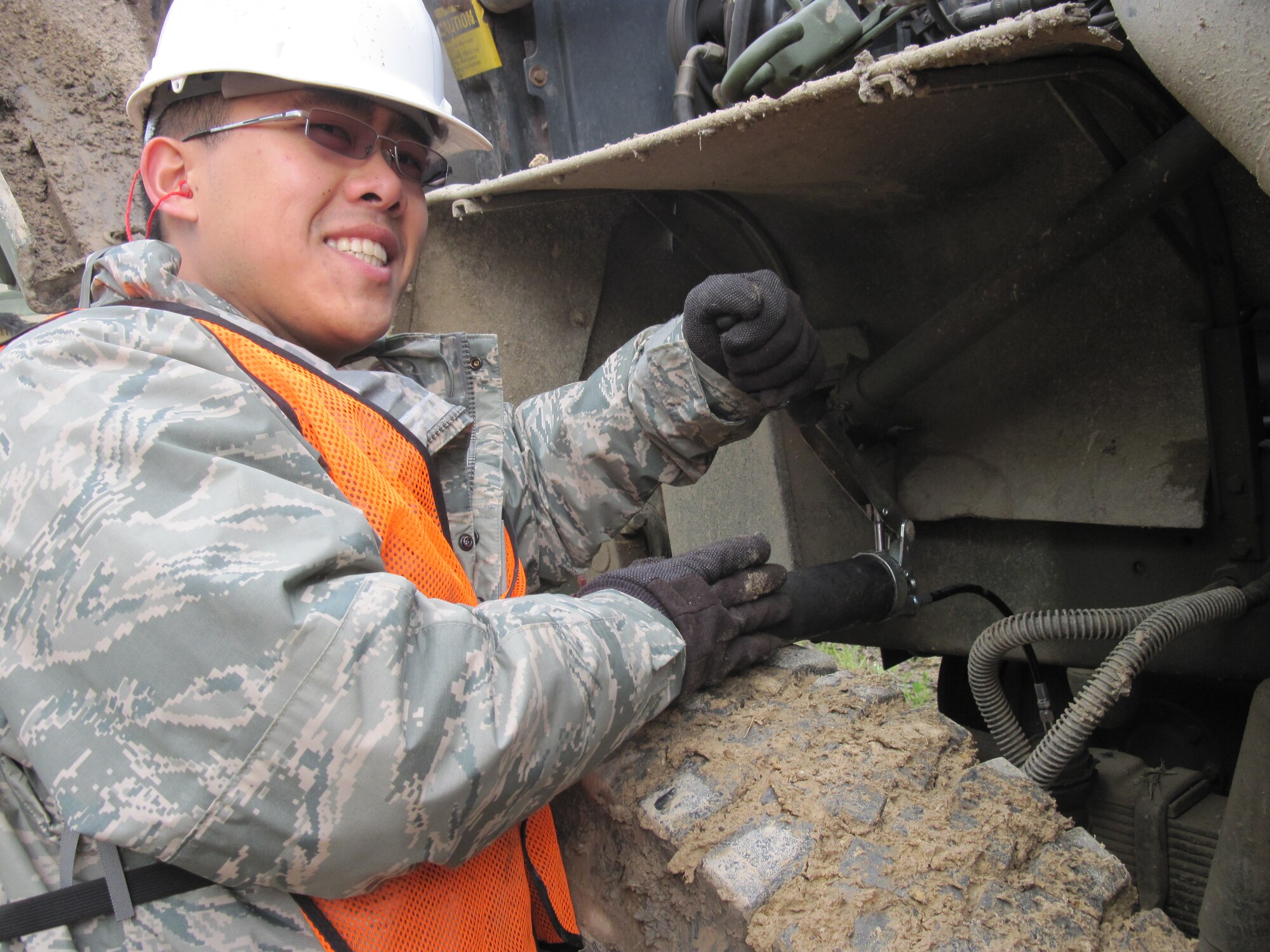 Senior Airman Soo Xiong, a Reservist with the 477th Civil Engineer Squadron,  greases up heavy equipment as preventative maintenance during construction of the Boy Scout Jamboree site. Twenty-two Arctic Reservists from Joint Base Elmendorf-Richardson, Alaska traveled to Beckley, W. Va. to begin work on a 10,600 acre site. (Photo by Master Sgt. Brede Emtman)