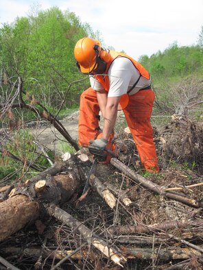 Tech. Sgt. Teo Mejaperatla, a Reservist with the 477th Civil Engineer Squadron, de-limbs a tree before it is shipped off to make into lumber during construction of the Boy Scout Jamboree site. Twenty-two Arctic Reservists traveled to Beckley, W. Va. to begin work on a 10,600 acre site. (Photo by Master Sgt. Brede Emtman)
