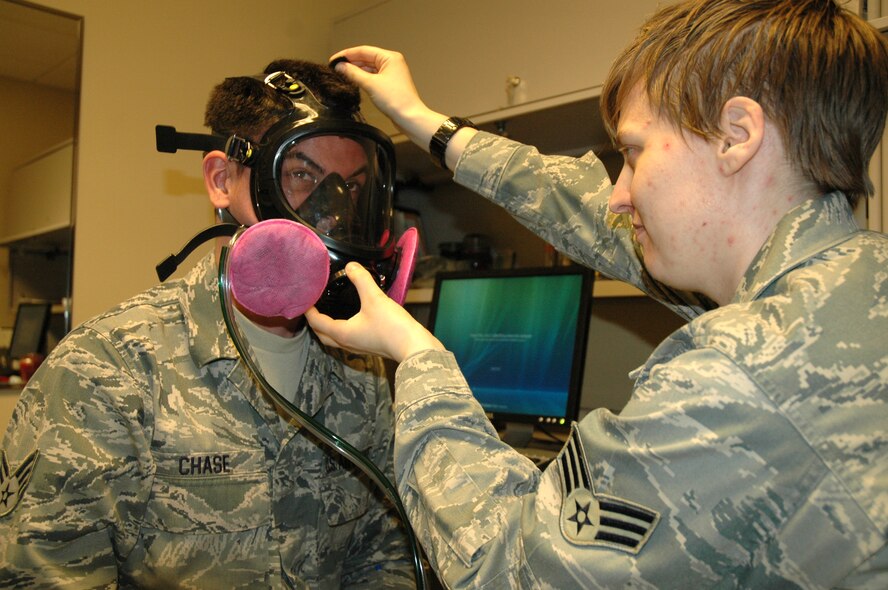 U.S. Air Force Senior Airman Catherine Pearce, 446th Aerospace Medicine Squadron, bioenvironmental engineering technician out of McChord Field, Wash., fits a gas mask for U.S. Air Force Senior Airman Matt Chase, 446th AMDS medical technician during the Reserve training weekend, May 21, 2011. Bioenvironmental engineers specialize in preventative measures to ensure a safe working environment in areas of occupational and environmental health. (U.S. Air Force photo by Staff Sgt. Elizabeth Moody/Released)
