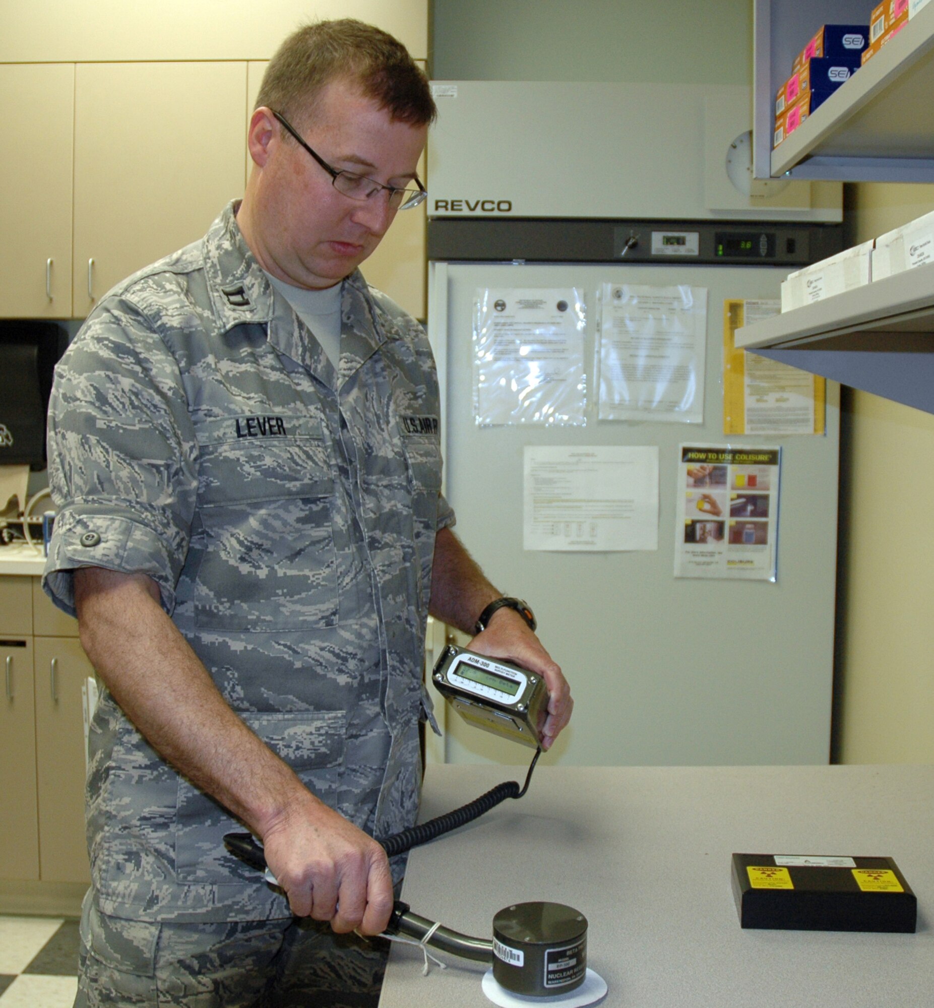 U.S. Air Force Capt. John Lever, 446th Aerospace Medicine Squadron, bioenvironmental engineer out of McChord Field, Wash., demonstrates how an ADM-300 detects, measures and digitally displays dose and dose rate levels of gamma and beta radiation.  It's the task of bioenvironmental engineers to ensure every work area is a safe one. Blending engineering and preventive medicine, bioenvironmental engineers identify and evaluate potential hazards and develop plans and programs to prevent injuries and illnesses. (U.S. Air Force photo by Staff Sgt. Elizabeth Moody/Released)